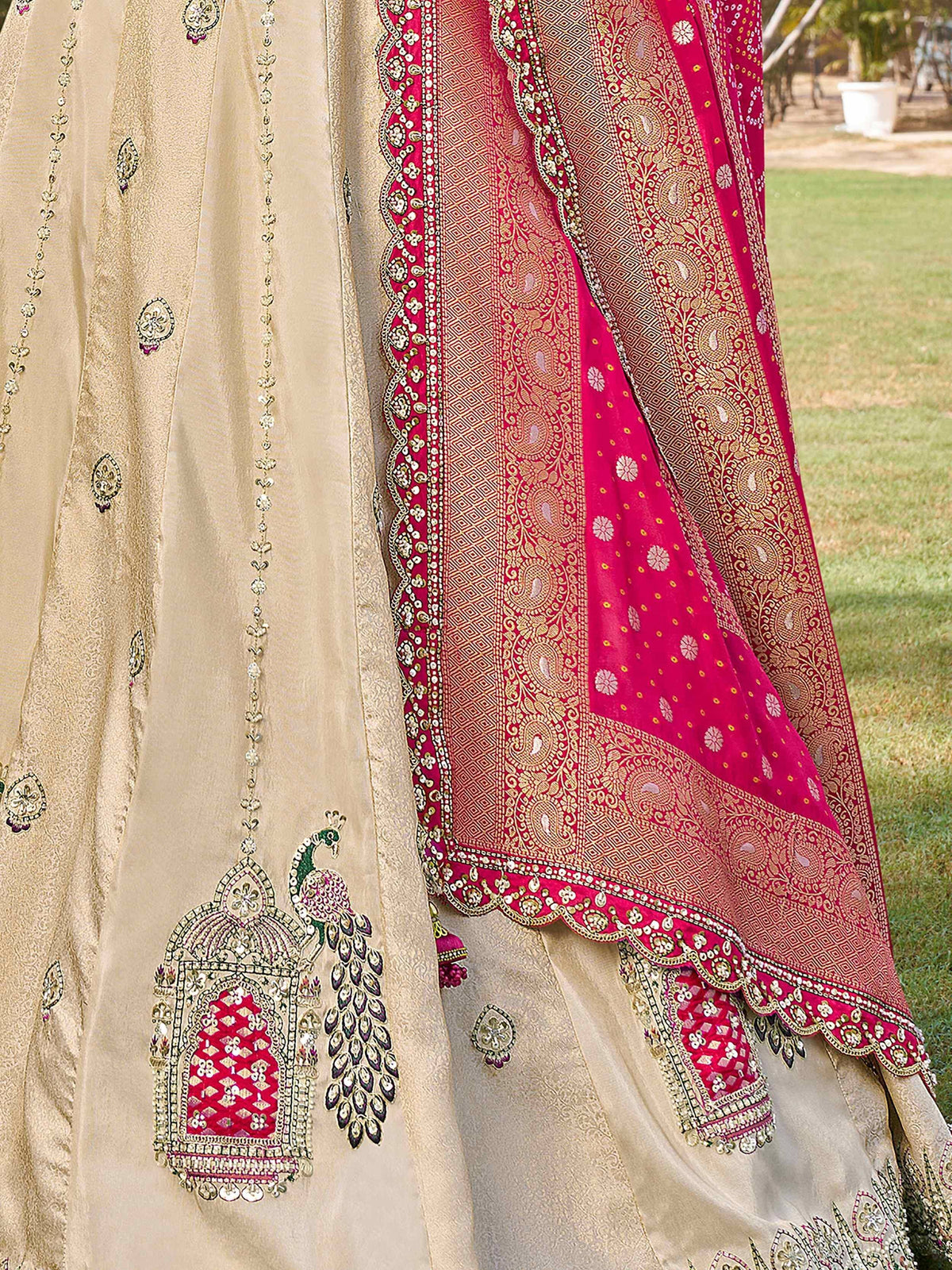 Beige and pink embroidered lehenga choli with peacock motif and zari work, perfect for Indian ethnic wear.