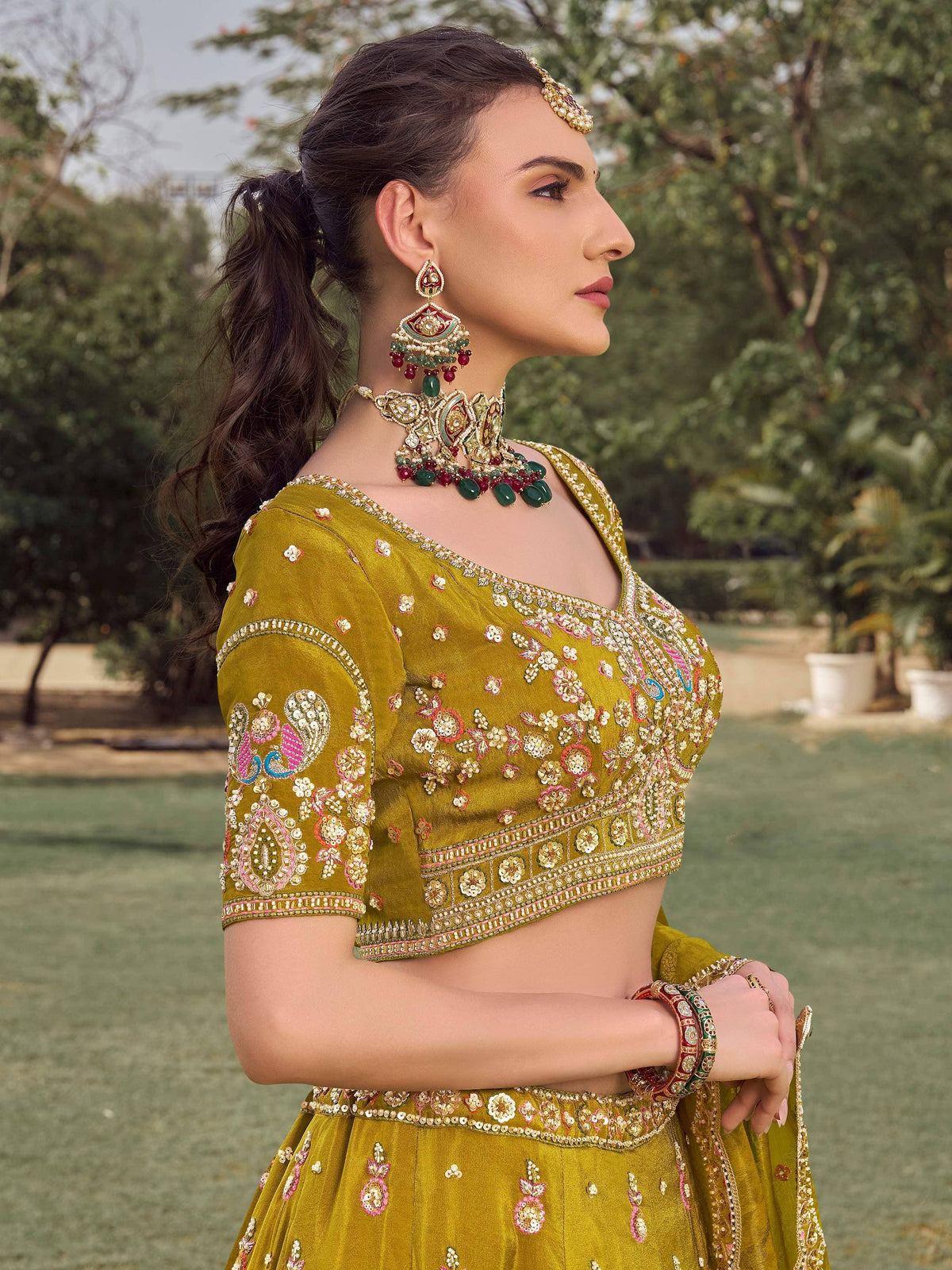 Elegant mustard yellow lehenga choli with intricate floral embroidery and traditional jewelry
