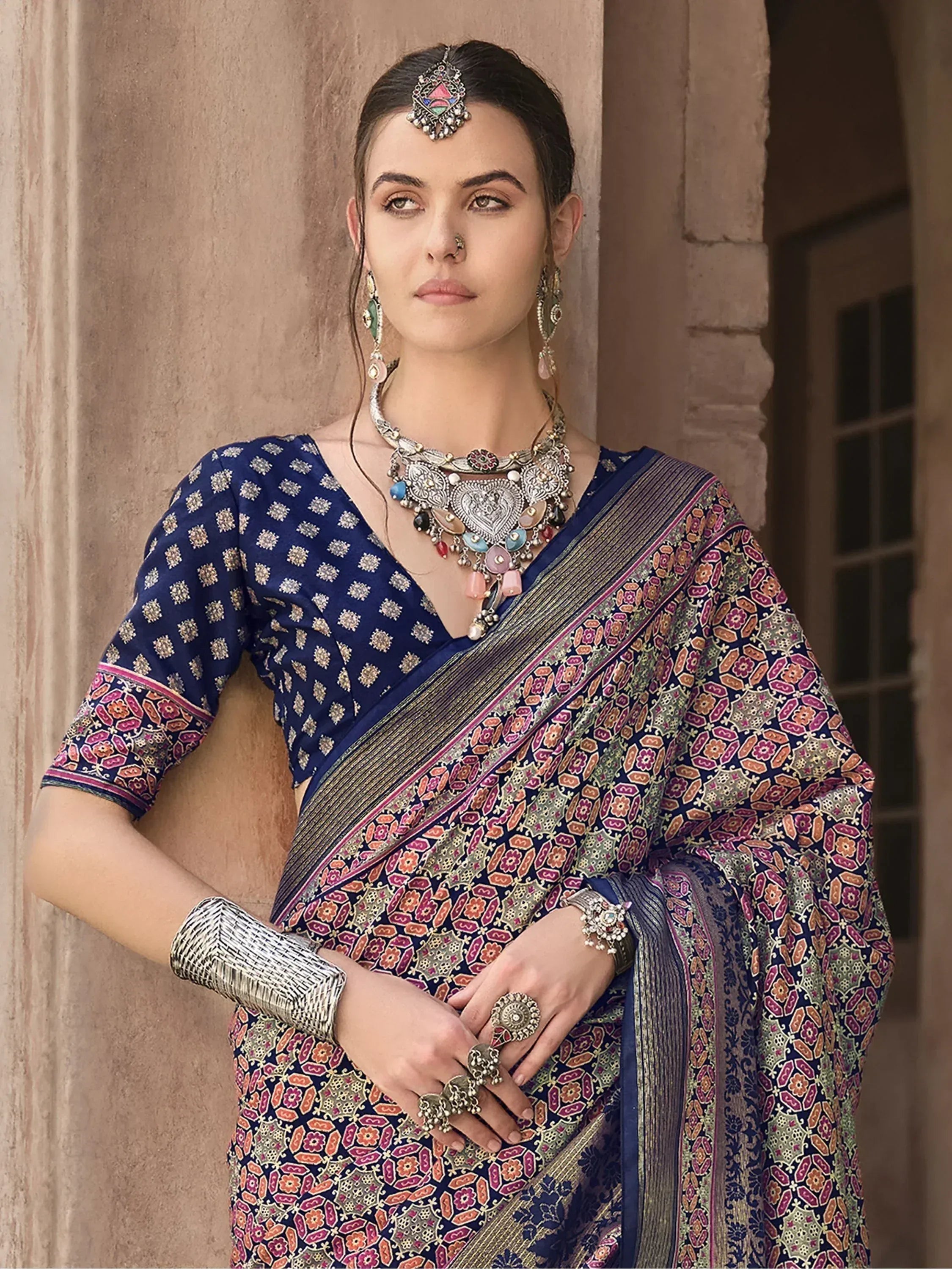 Woman in blue printed saree with ethnic jewelry, traditional Indian attire for festive occasions