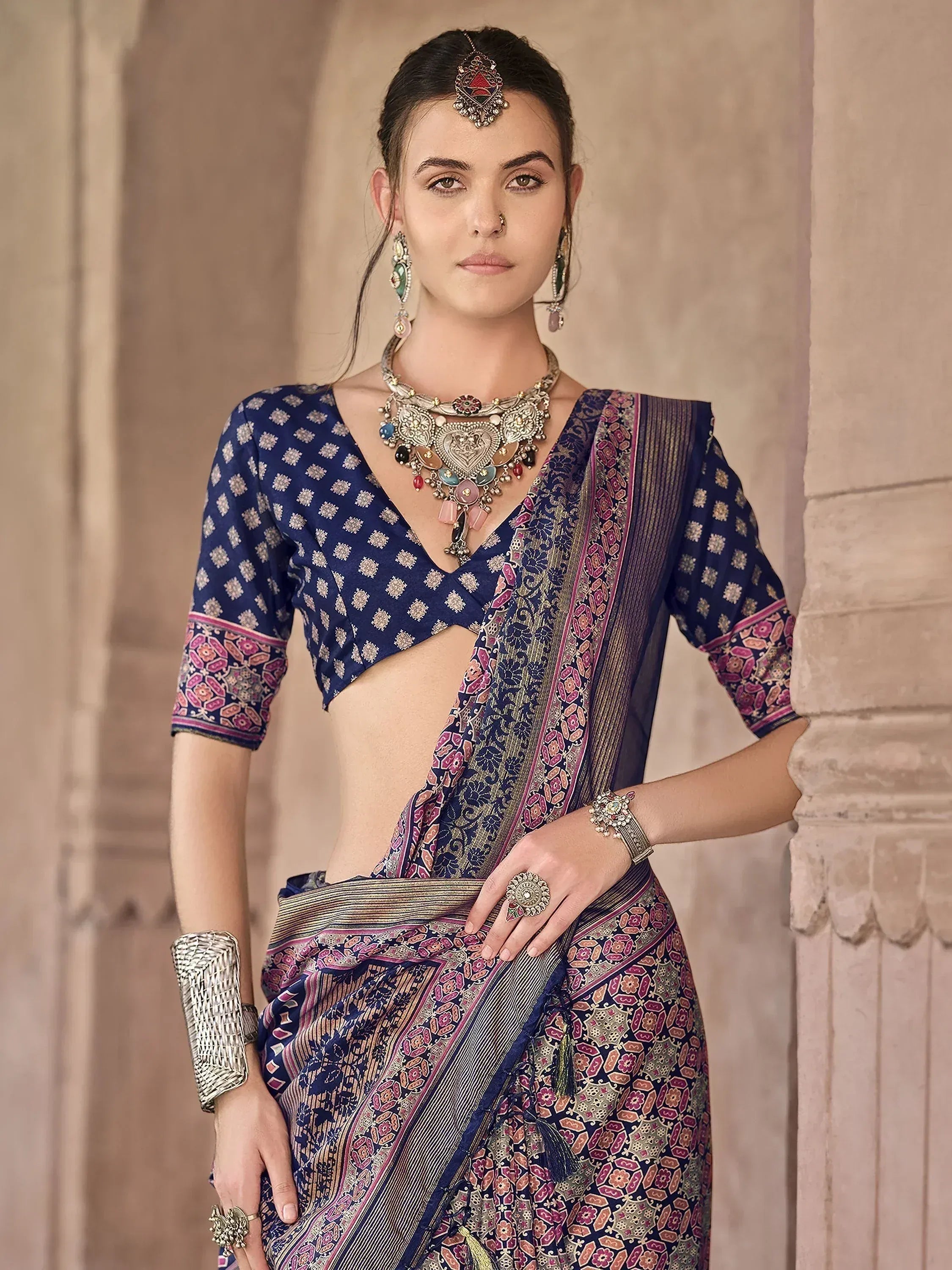 Woman in navy blue printed saree with ethnic jewelry, traditional Indian attire for festive occasions
