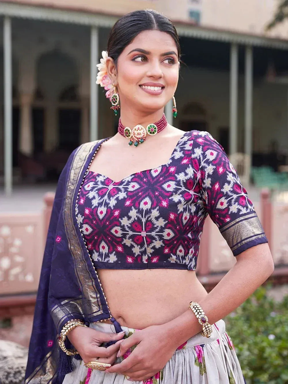 Woman in ethnic Indian lehenga choli with floral print blouse and dupatta, styled with traditional jewelry