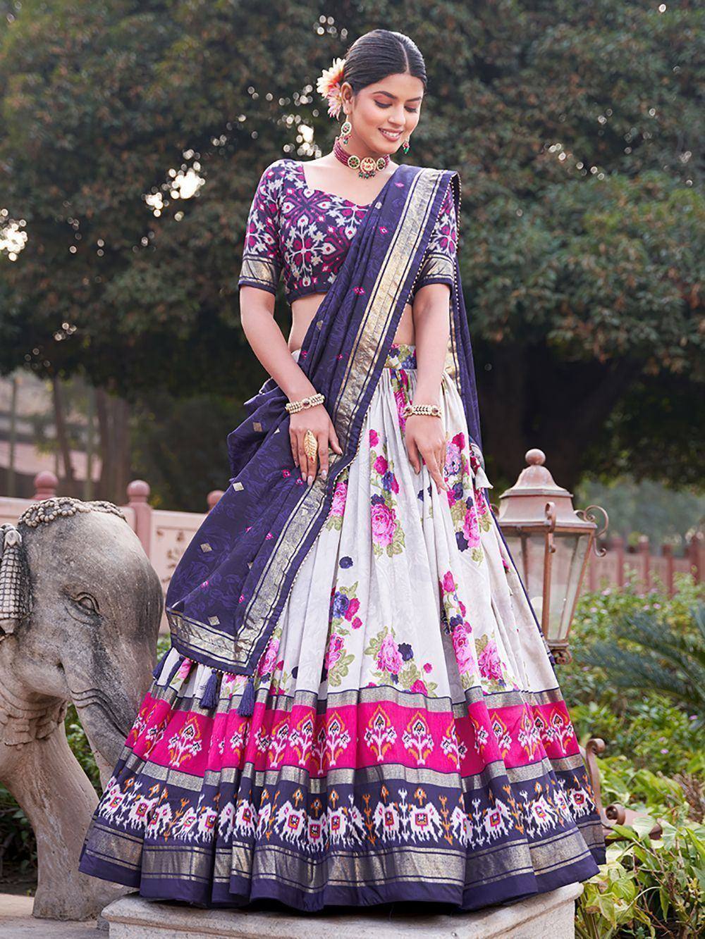 Woman in floral print lehenga choli with purple dupatta, traditional Indian ethnic wear for weddings or festivals