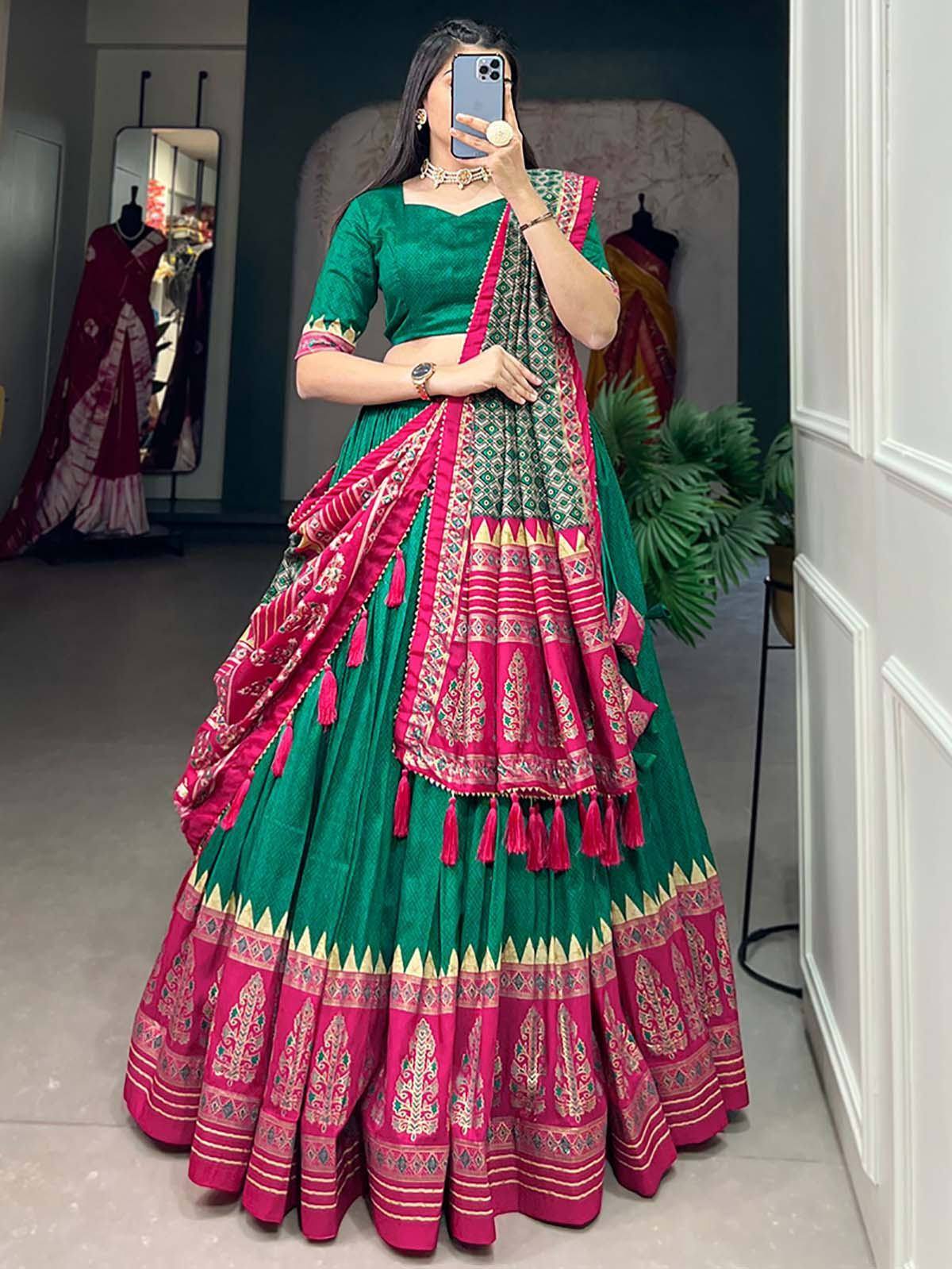 Green and pink designer lehenga choli with intricate embroidery and tassels, perfect for Indian ethnic wear.