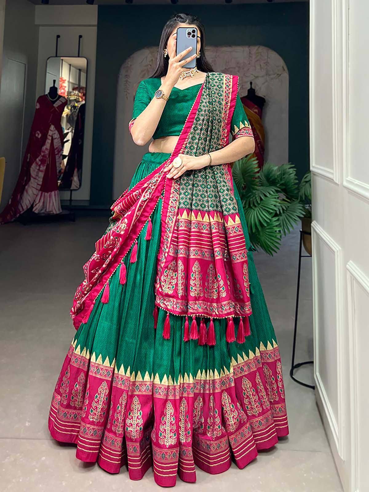 Green and pink designer lehenga choli with intricate embroidery and tassels, perfect for Indian ethnic occasions.