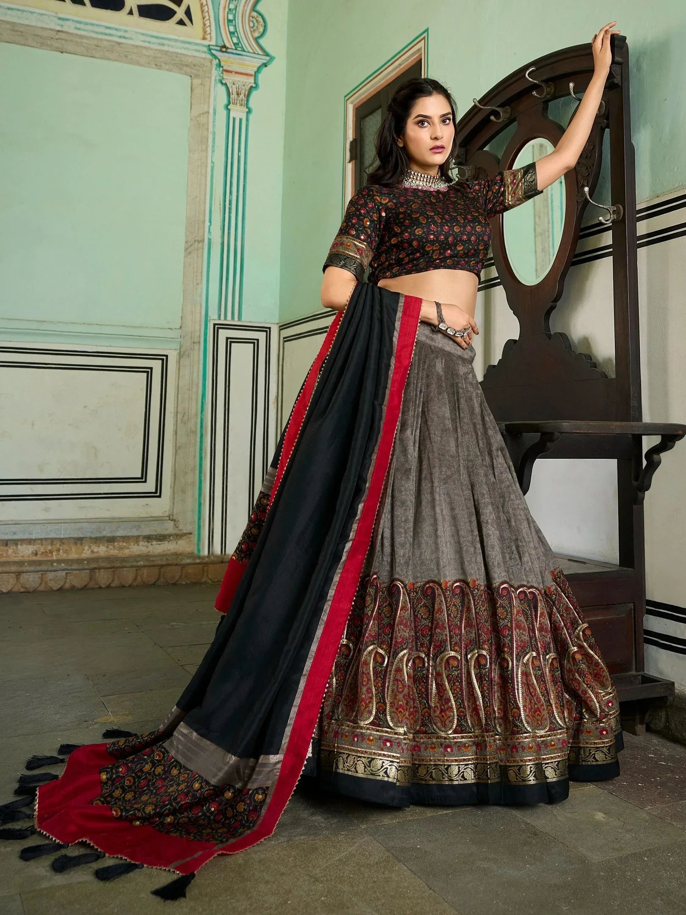 Elegant grey and black lehenga choli with red border, floral print blouse, and intricate paisley embroidery for Indian ethnic wear.