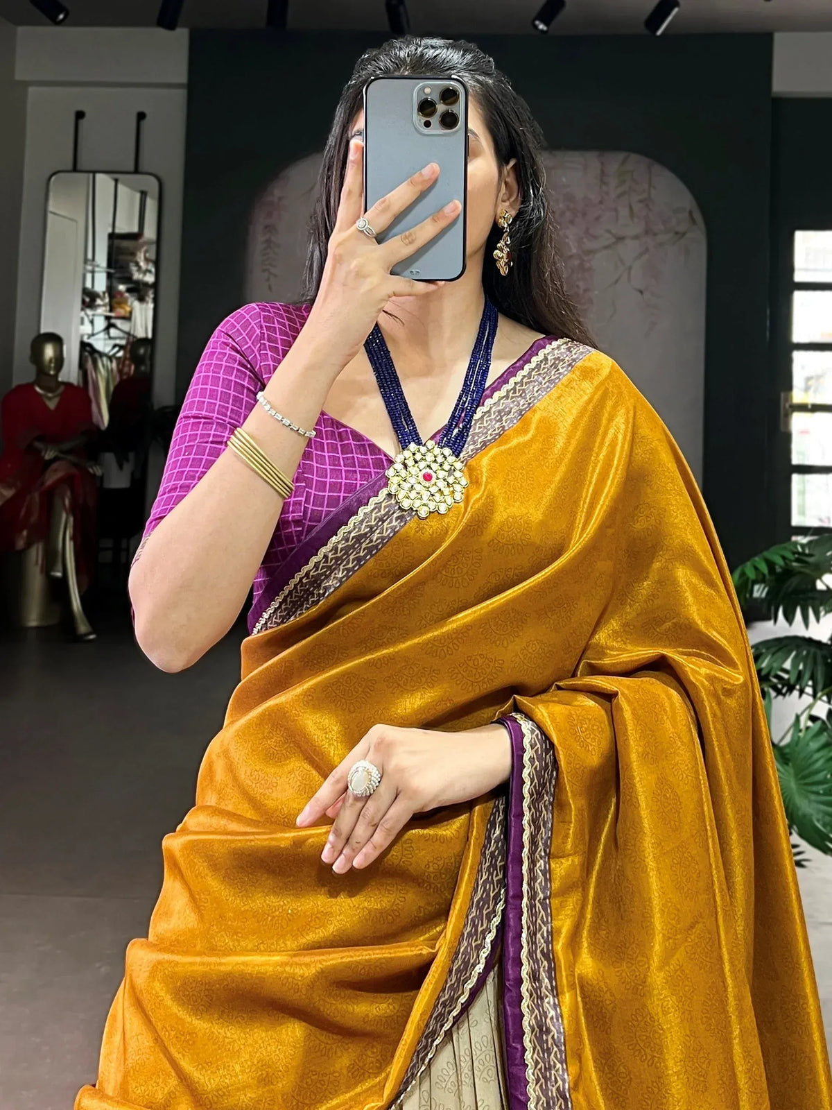 Woman in golden velvet saree with purple blouse, traditional Indian ethnic wear, perfect for festive occasions.