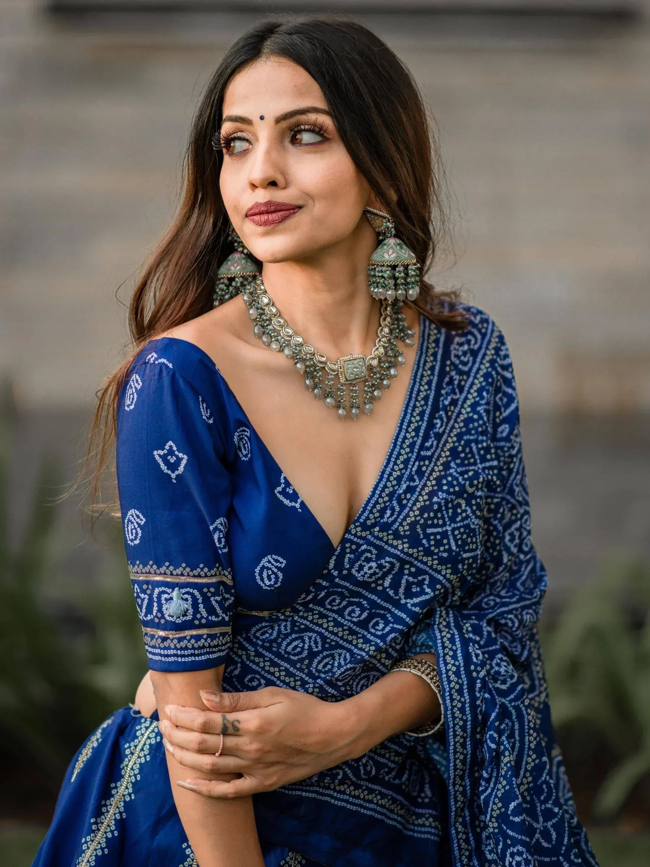 Blue printed ethnic gown with deep V-neck, paired with traditional jewelry for Indian wear