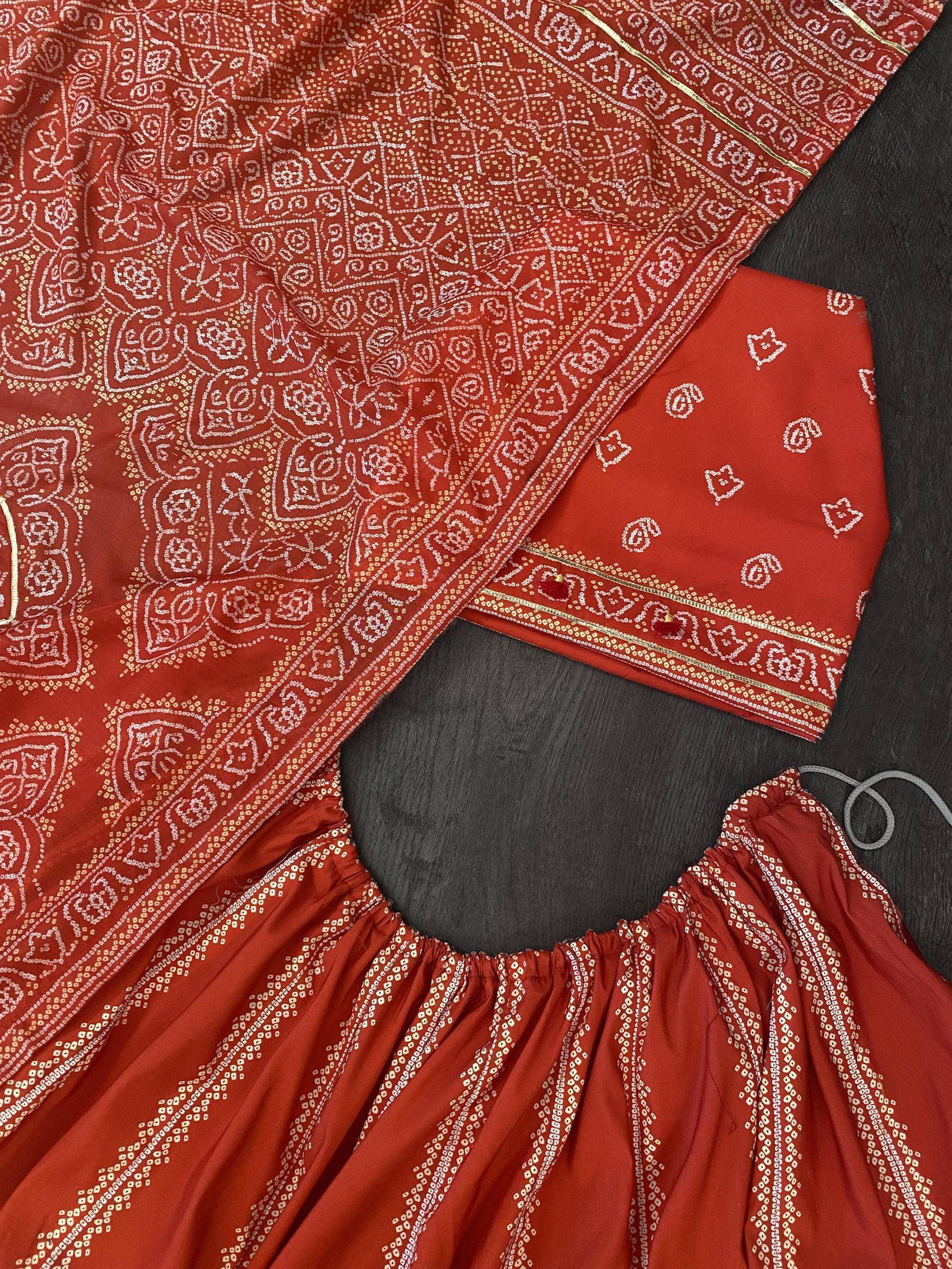 Red ethnic gown with white and gold bandhani print, perfect for Indian festive occasions