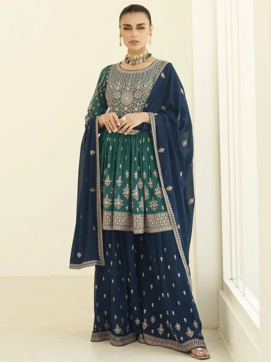 Woman wearing green and navy blue embroidered Indian salwar kameez with dupatta.