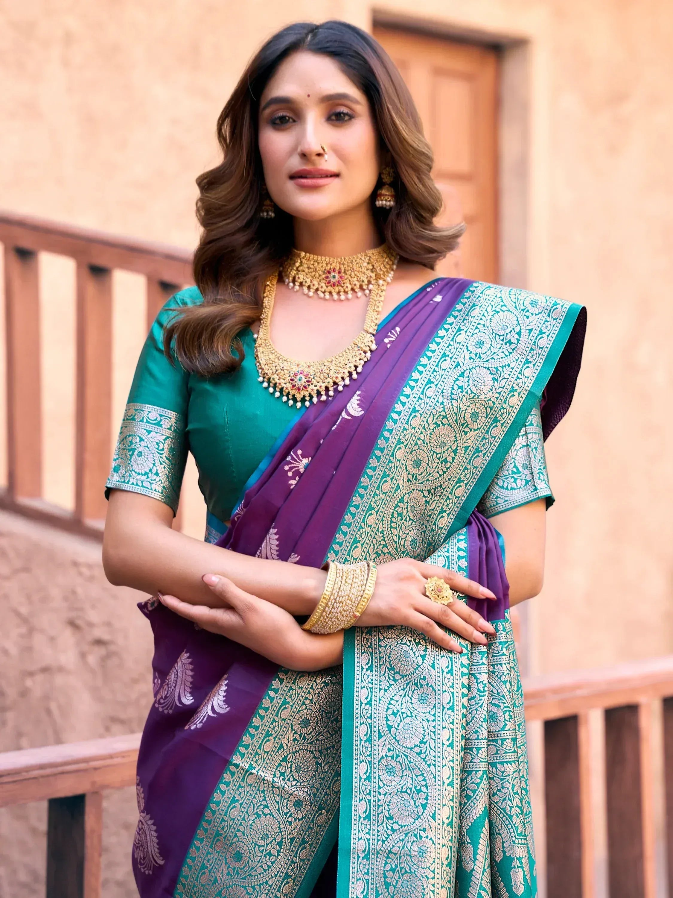 Woman in elegant purple and teal designer saree with gold embroidery, traditional Indian ethnic wear