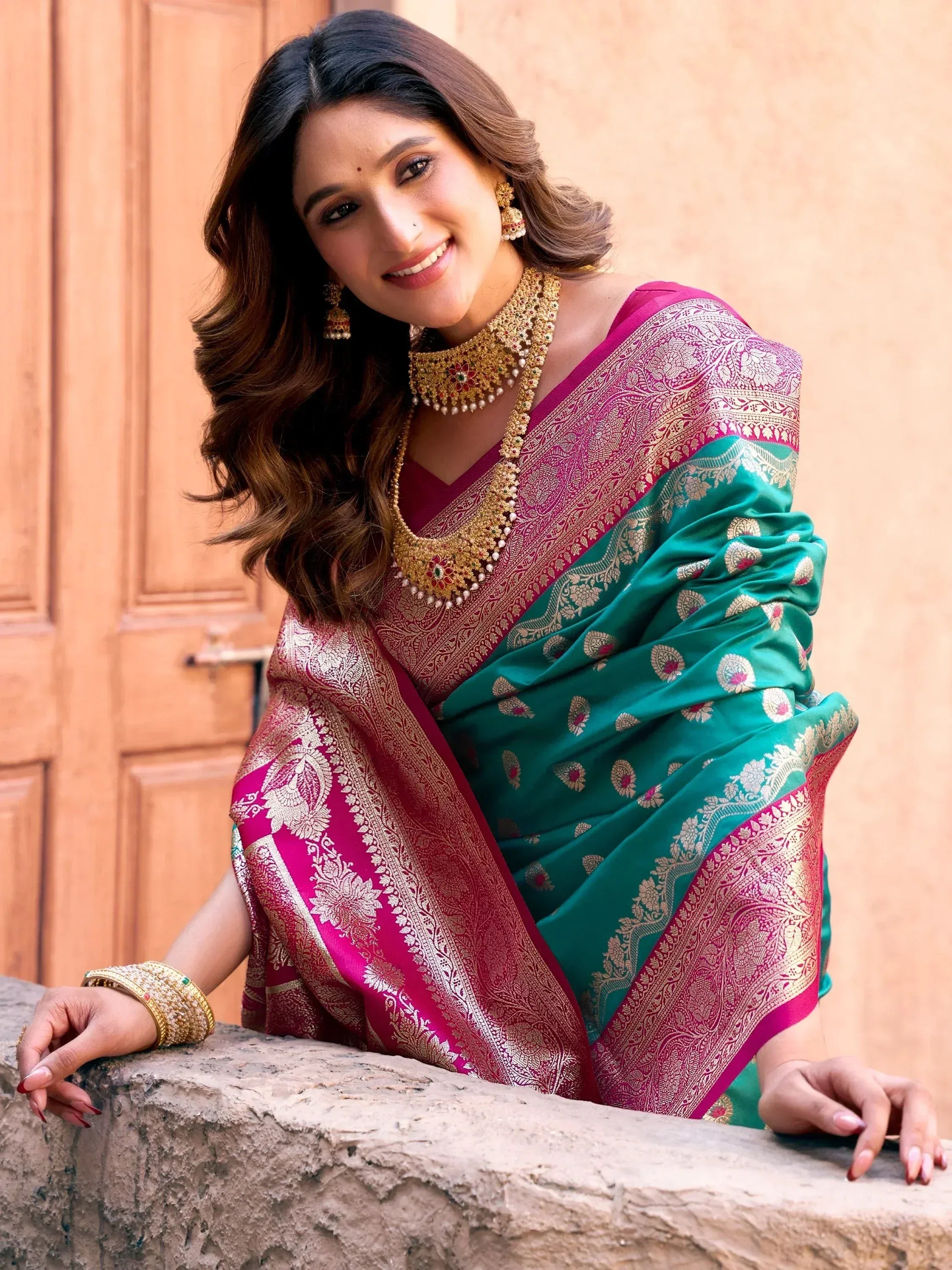 Woman in elegant green and pink silk saree with gold embroidery, traditional Indian ethnic wear
