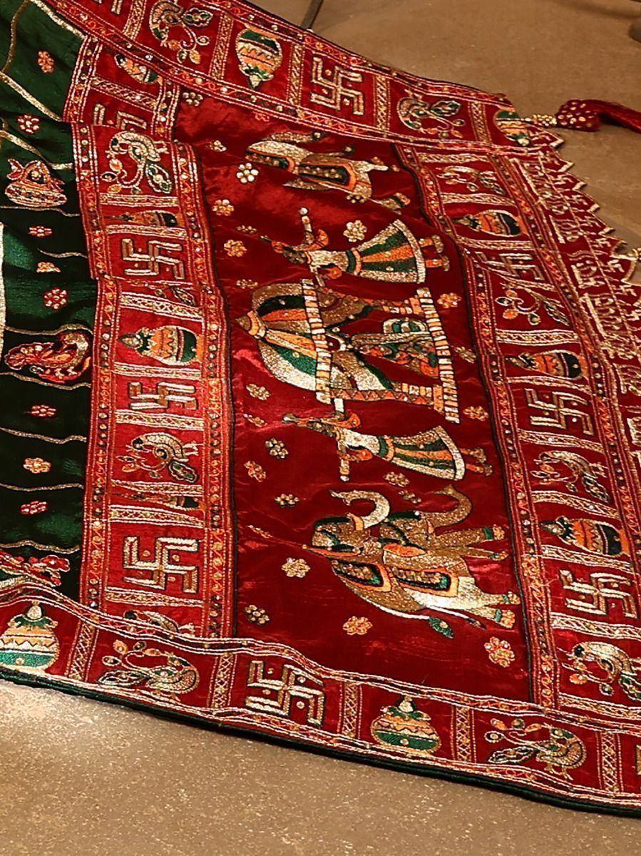 Richly embroidered red and green Indian ethnic fabric with traditional motifs and elephants