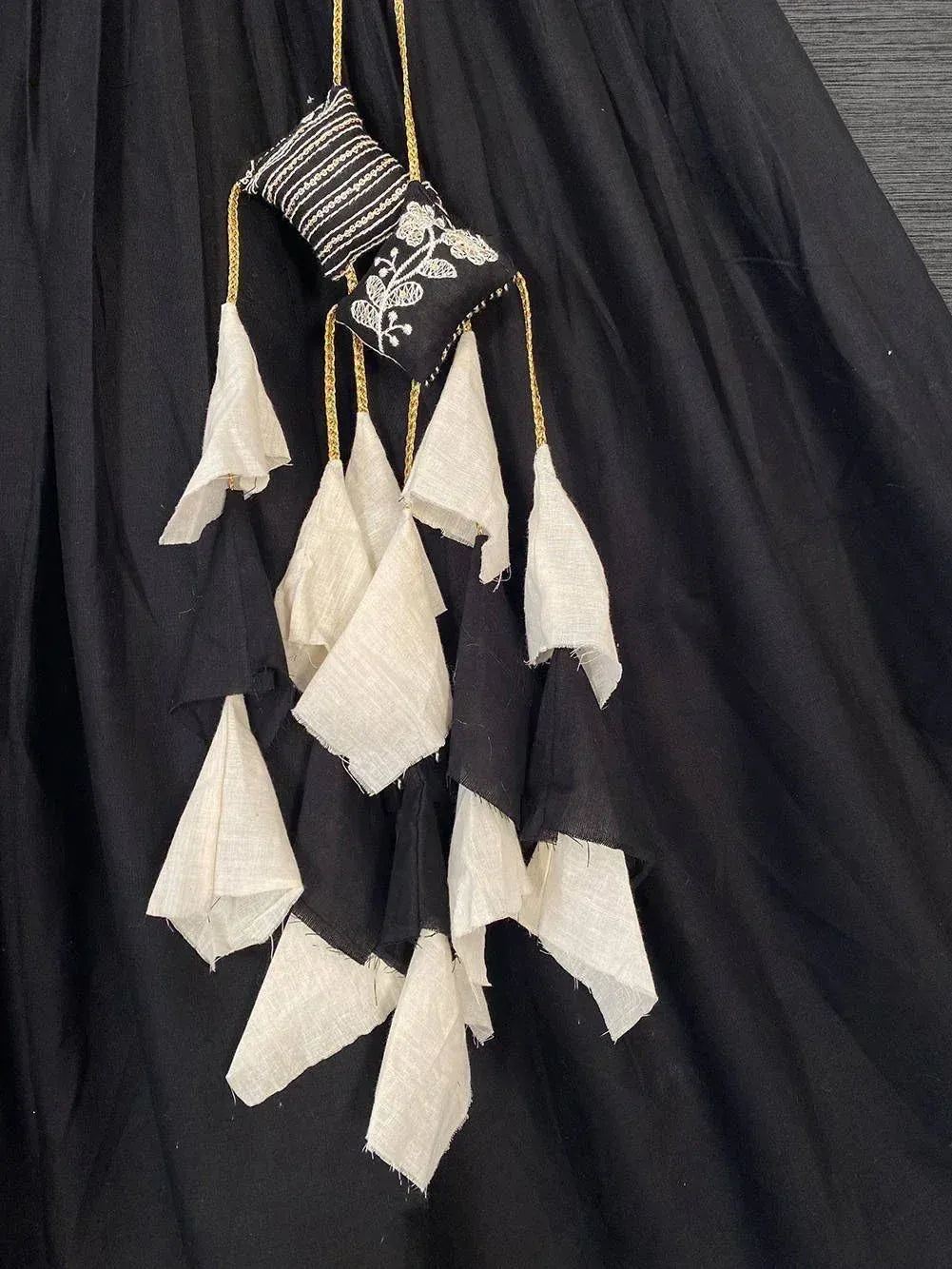 Black ethnic gown with white embroidered tassels and gold trim, perfect for Indian festive wear