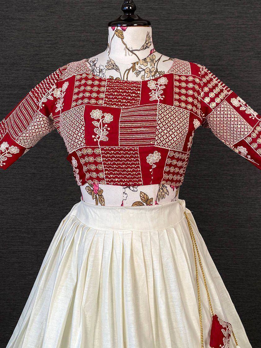 Red and white patchwork ethnic blouse with floral embroidery paired with cream pleated skirt