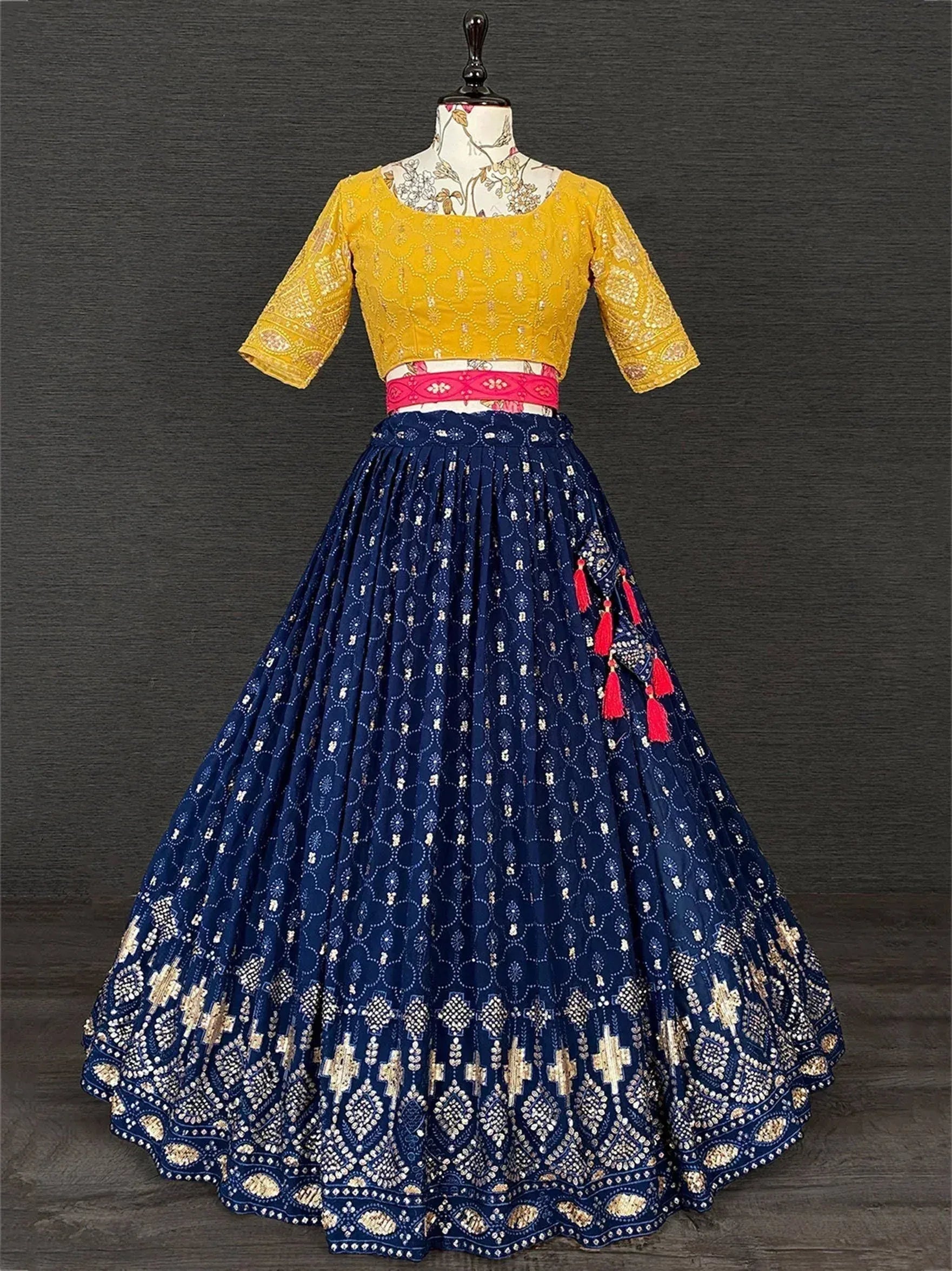 Yellow embroidered blouse with navy blue lehenga, pink belt, and red tassels — Indian ethnic wear