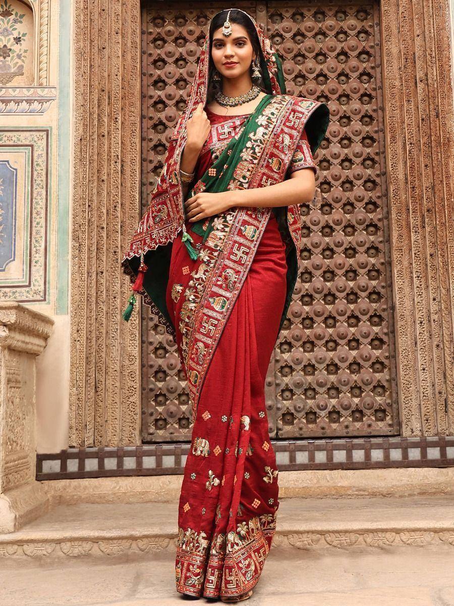 Red and green embroidered saree with traditional Indian motifs and jewelry