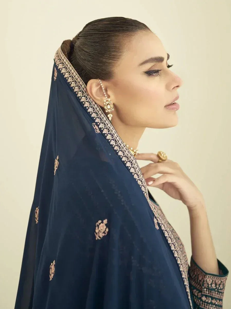 Woman in side profile wearing navy blue embroidered dupatta and traditional gold jewelry