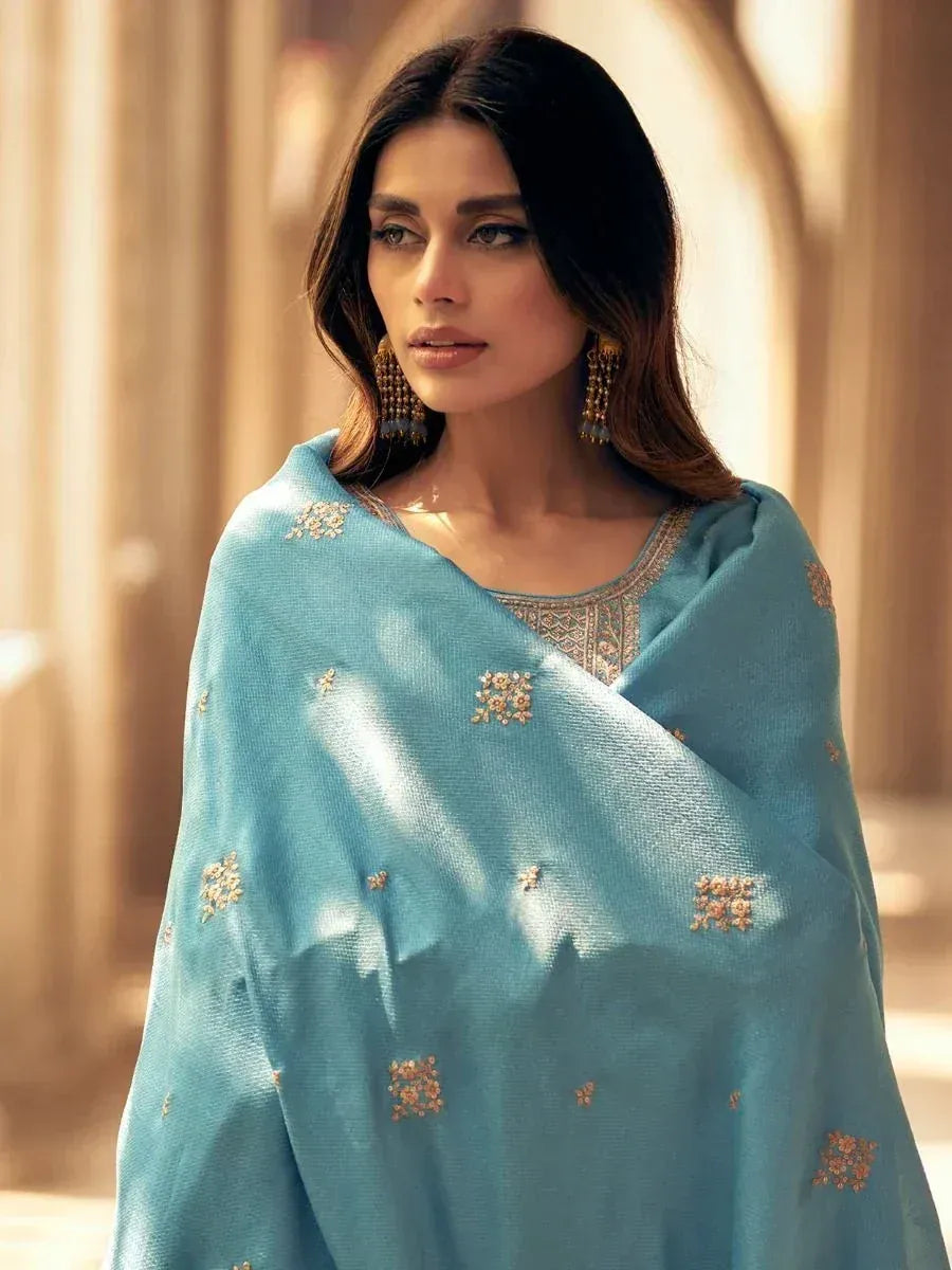 Woman in light blue embroidered ethnic salwar kameez with gold detailing, perfect for festive occasions