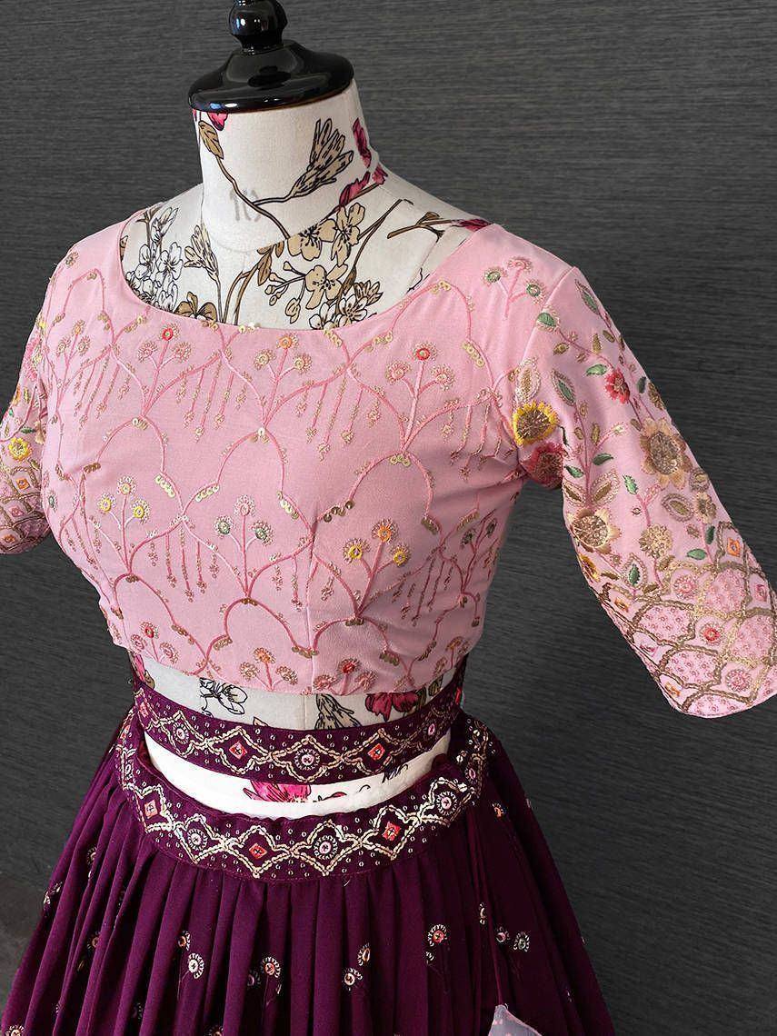 Pink embroidered blouse with floral motifs paired with maroon lehenga, ideal for Indian ethnic wear