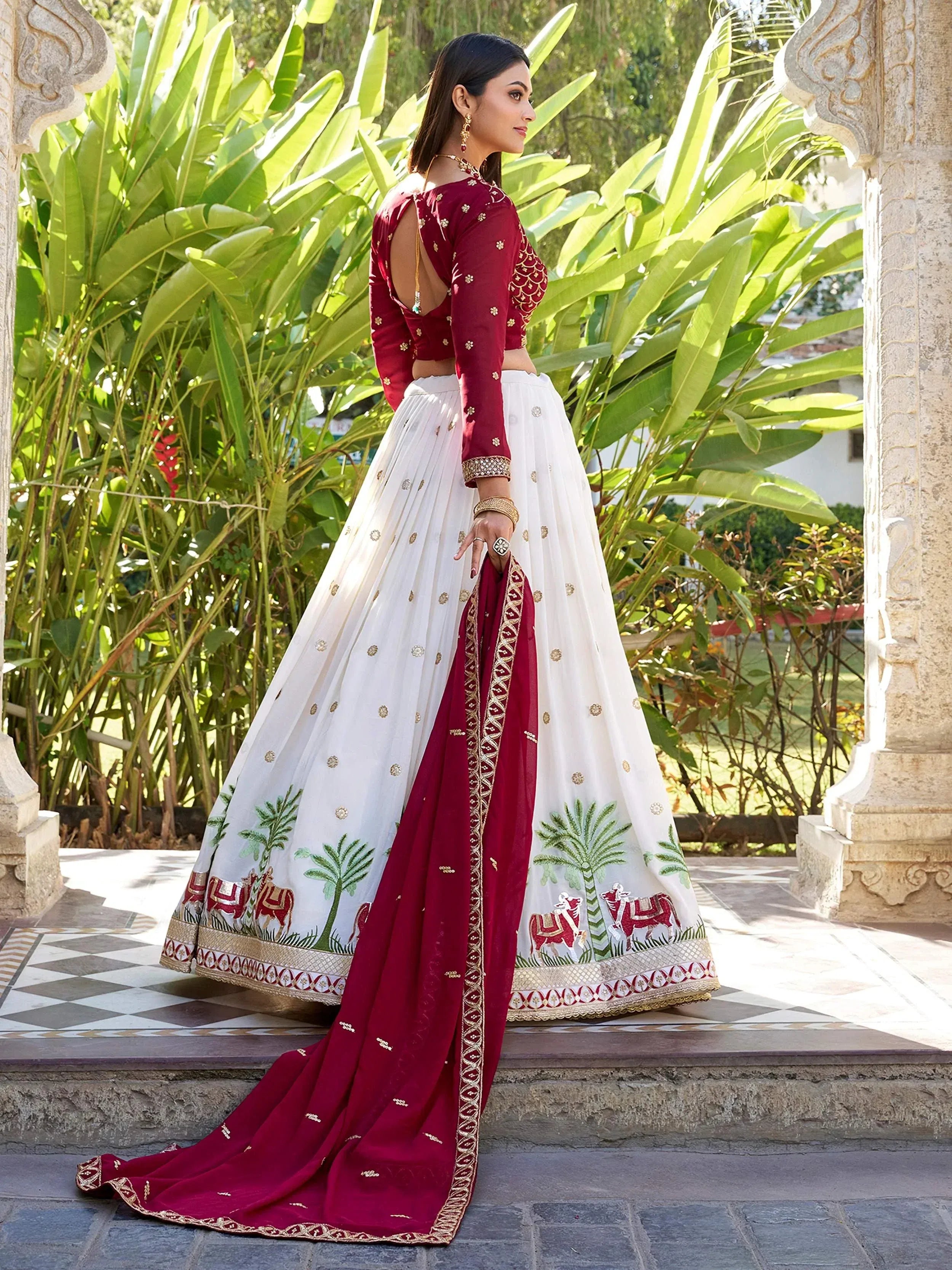 White and maroon lehenga choli with embroidered elephants and palm trees, perfect for Indian ethnic wear occasions.