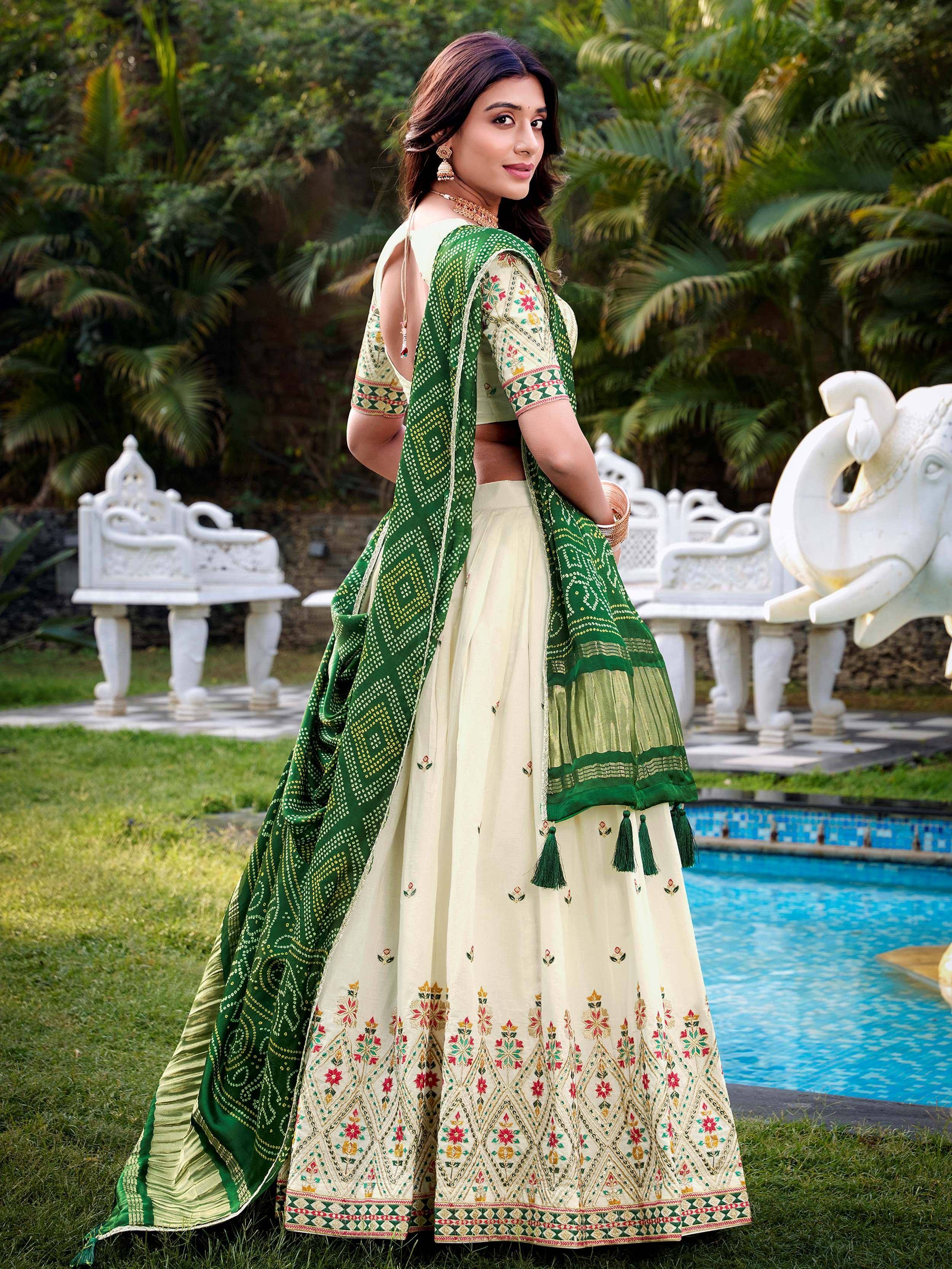 Cream and green embroidered lehenga choli with floral patterns, perfect for Indian ethnic wear occasions.