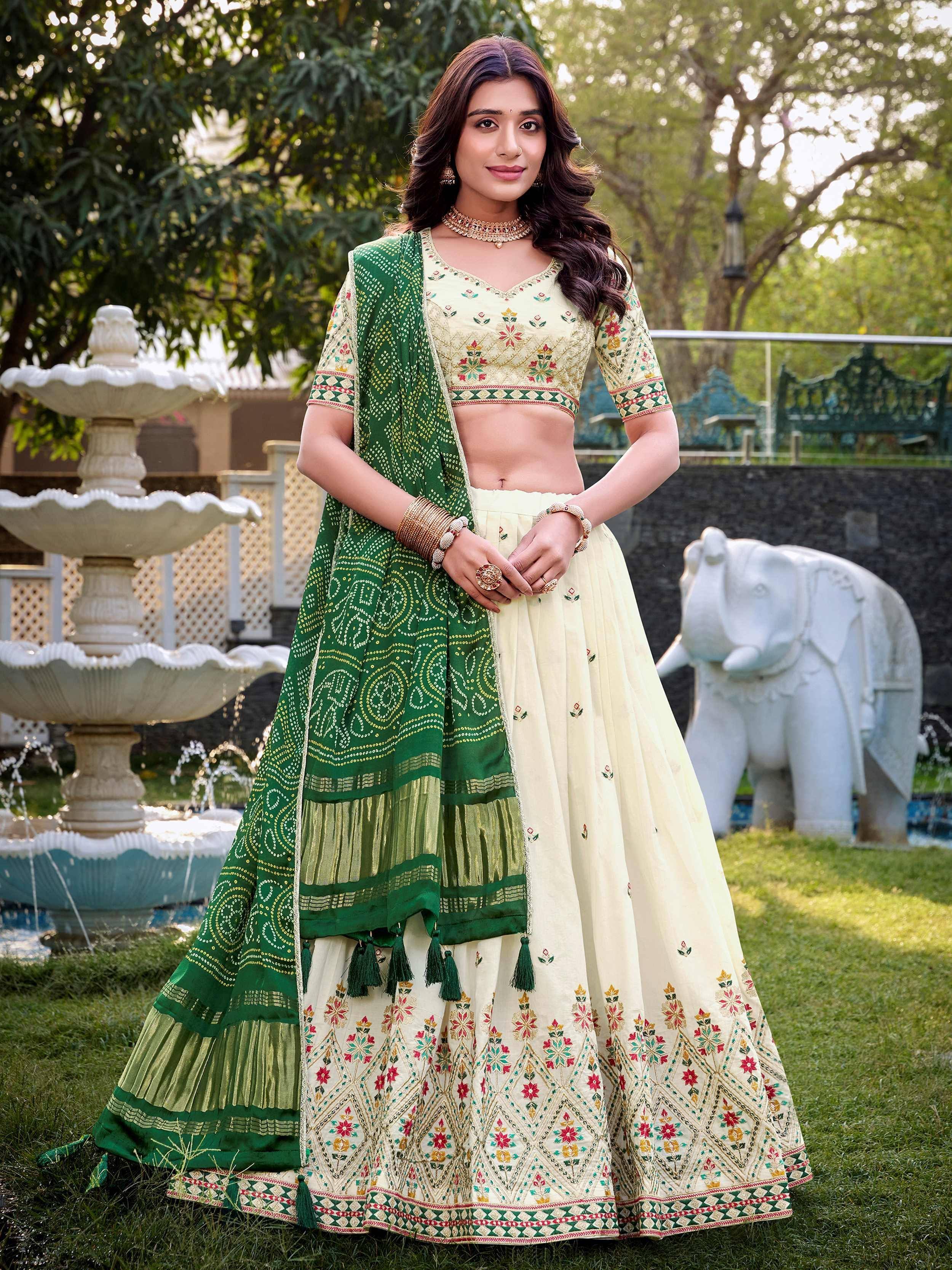 Cream and green embroidered lehenga choli with floral motifs, perfect for Indian ethnic wear events.