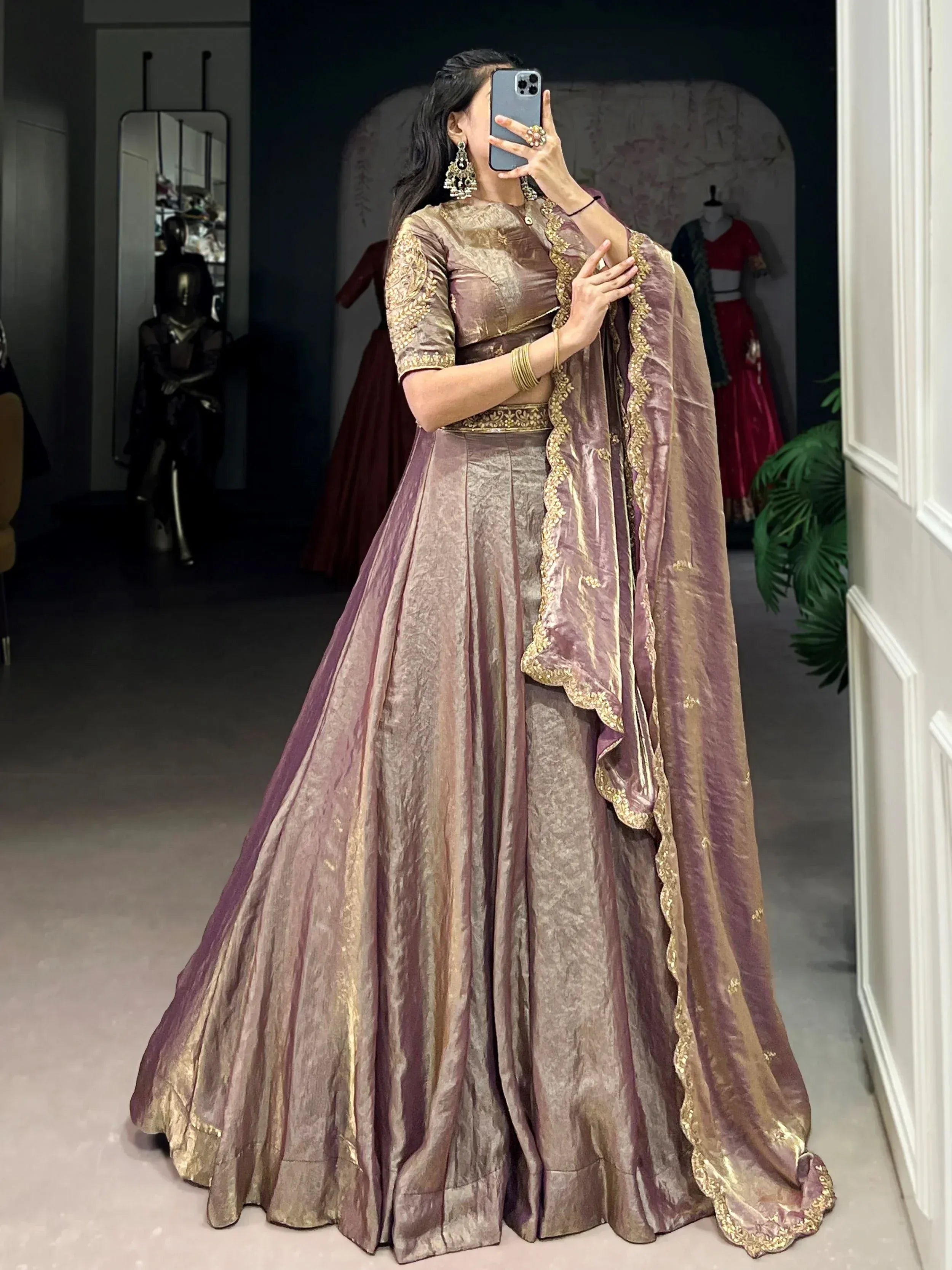Woman in elegant mauve and gold lehenga choli with intricate embroidery, perfect for Indian ethnic wear occasions.