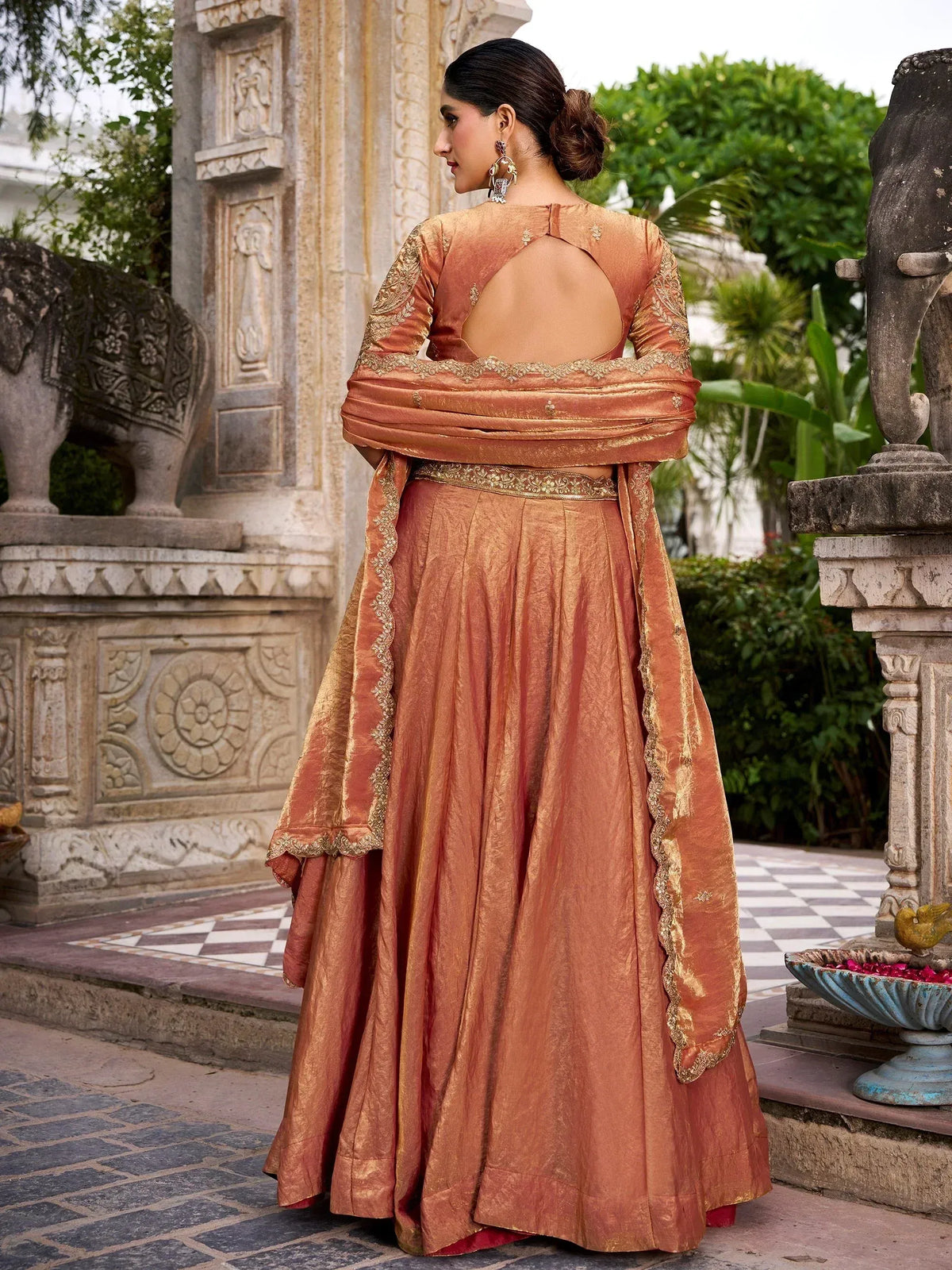Elegant peach lehenga choli with gold embroidery, back view, perfect for Indian ethnic wear occasions