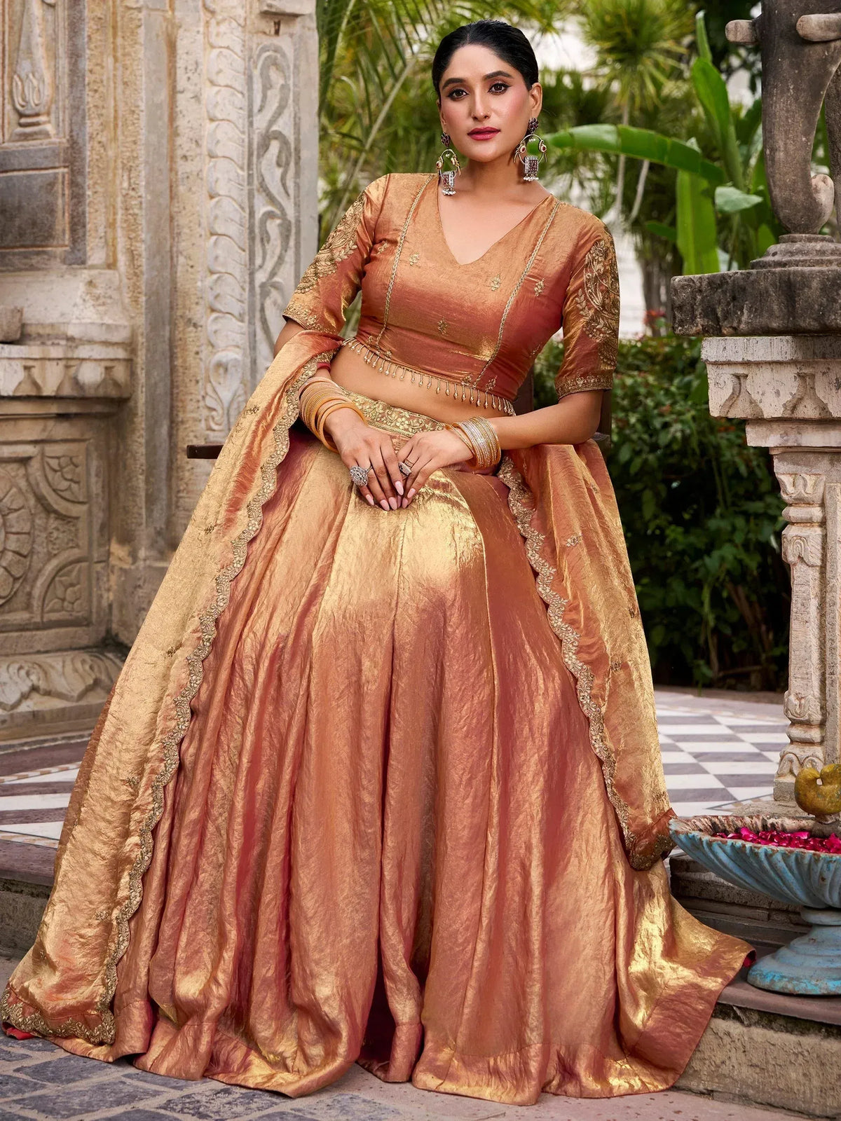 Elegant peach and gold designer lehenga choli with intricate embroidery, perfect for Indian weddings and festive occasions.