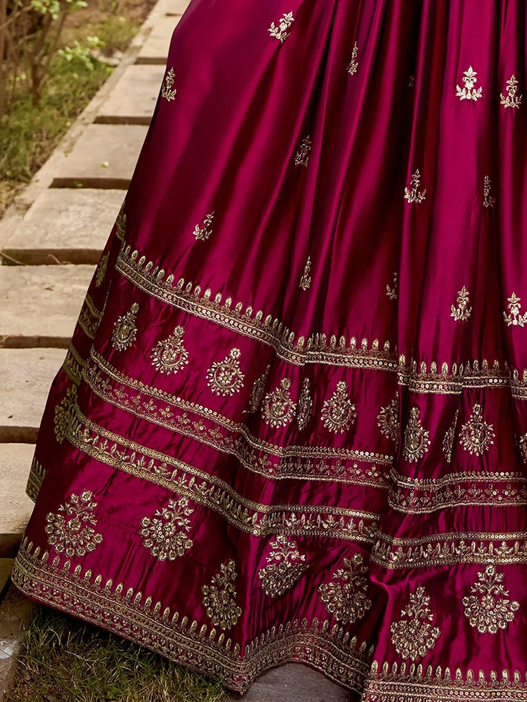 Rich maroon lehenga with intricate gold embroidery and layered borders, perfect for ethnic occasions.