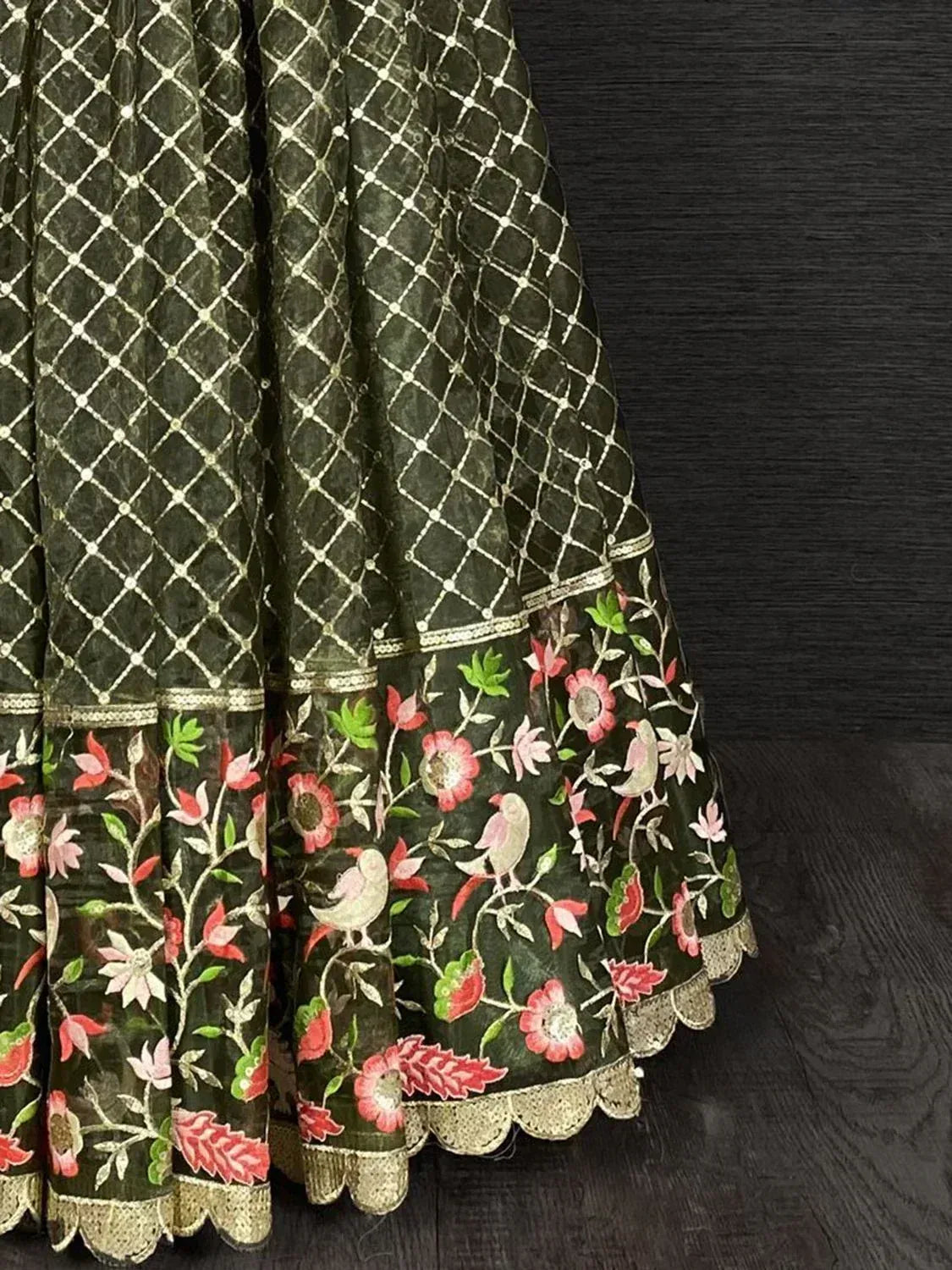 Dark green lehenga with gold lattice and floral bird embroidery, scalloped hem detail
