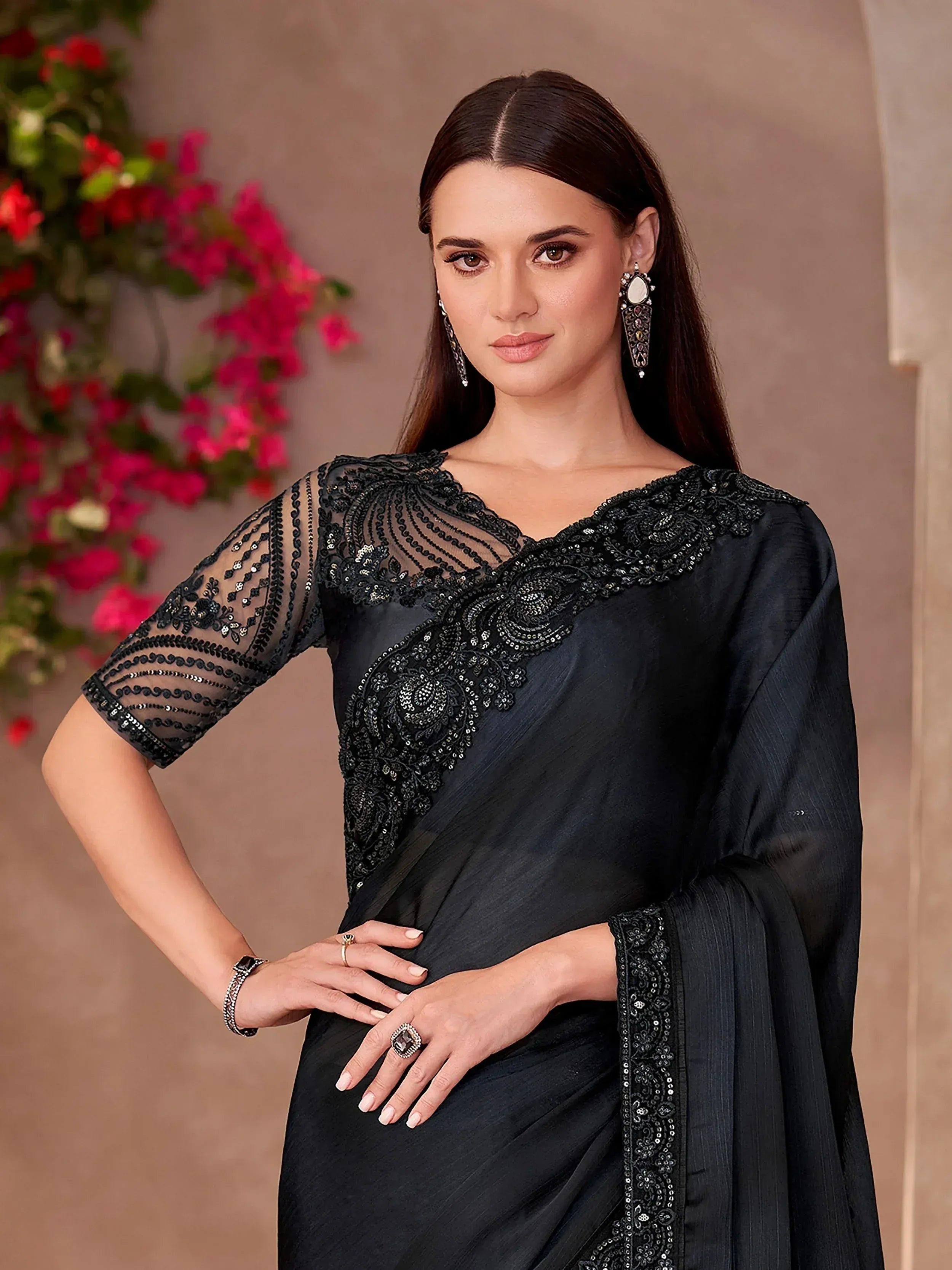 Elegant black saree with intricate sequin embroidery and sheer sleeves, perfect for Indian ethnic occasions.