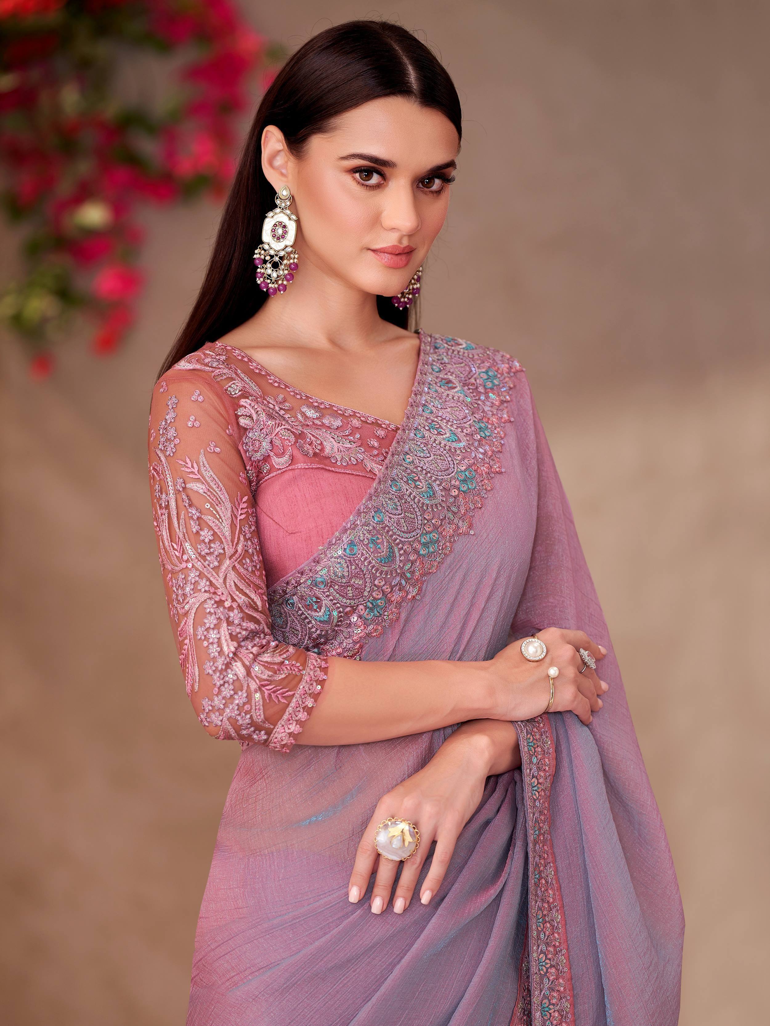 Elegant pink embroidered saree with sheer sleeves and statement earrings, perfect for Indian ethnic occasions