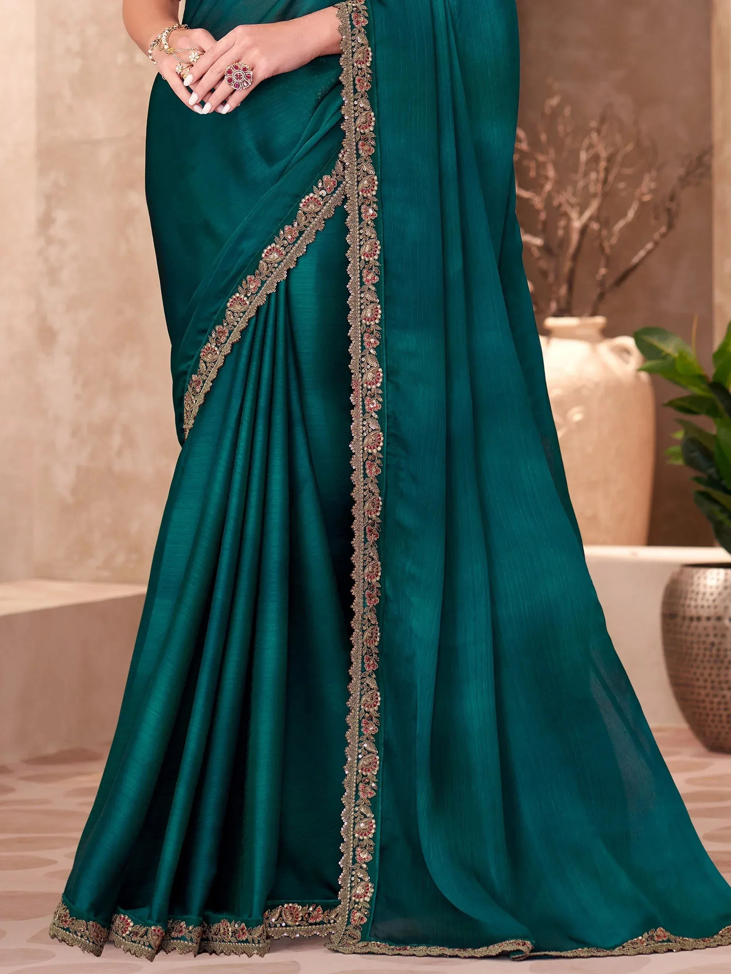 Emerald green designer saree with gold and red floral embroidery, perfect for Indian ethnic wear occasions.