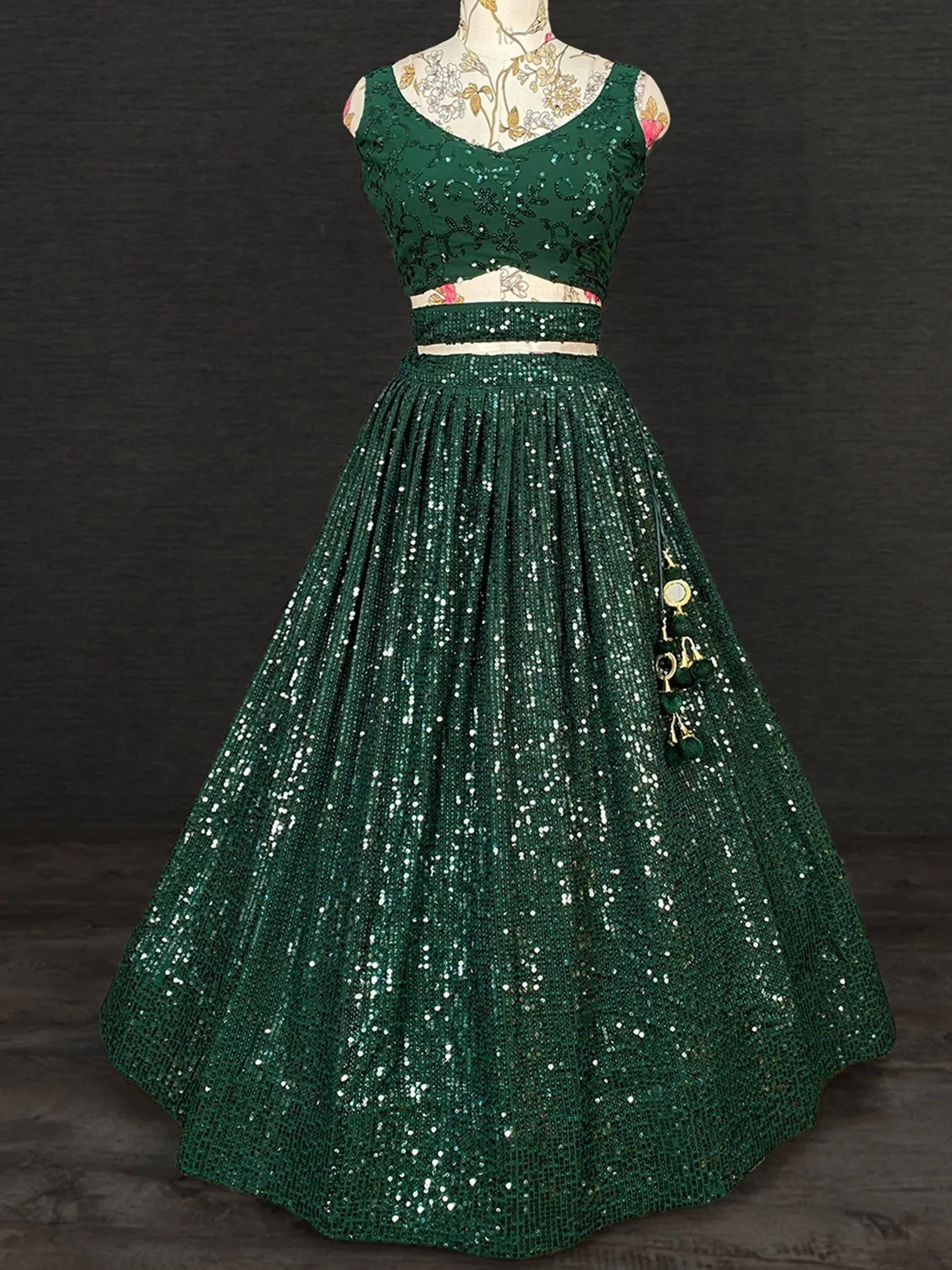Emerald green sequin lehenga choli with floral embroidery and tassel detail, perfect for Indian ethnic occasions.