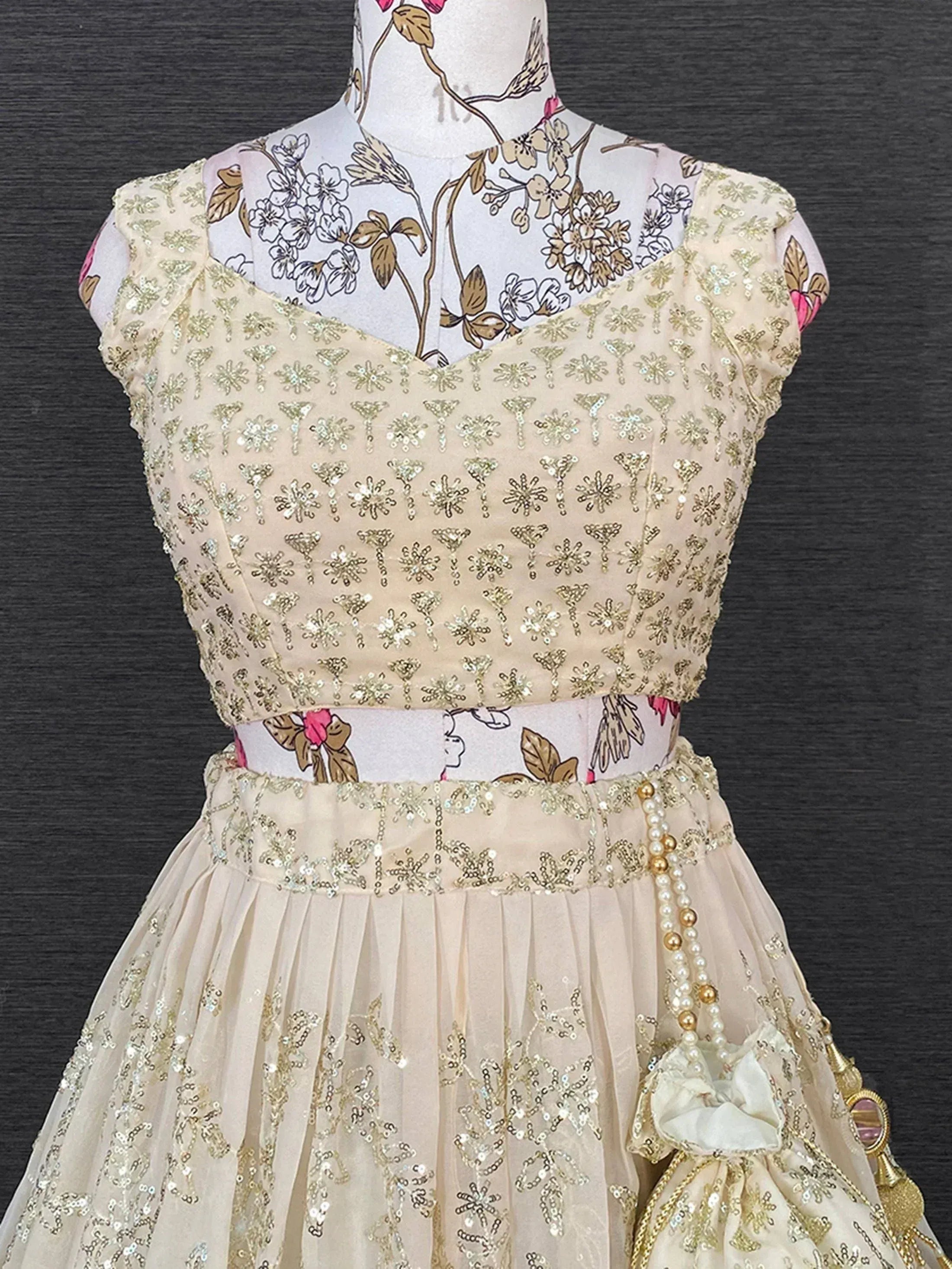 Cream sequin lehenga choli with floral embroidery, perfect for Indian ethnic wear and festive occasions.