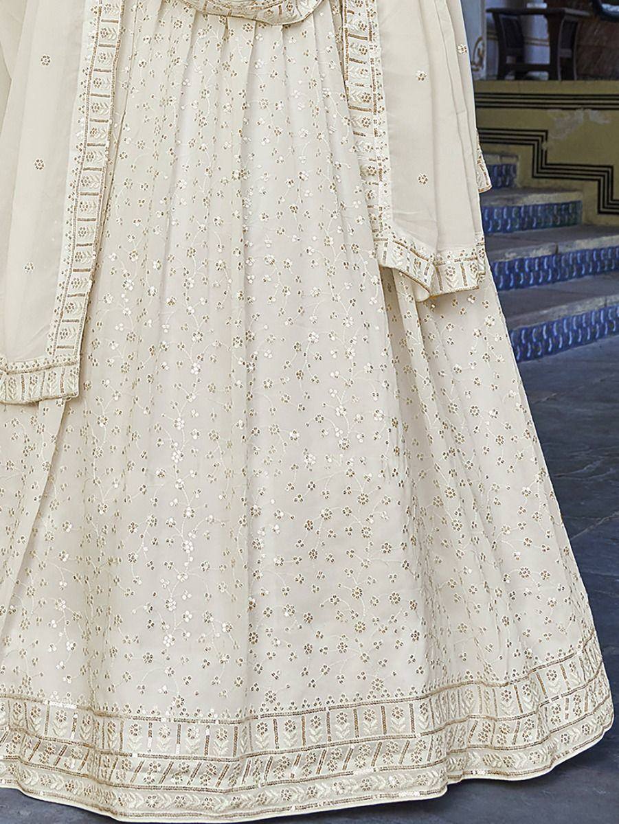 Cream embroidered lehenga choli with floral motifs and gold border, ideal for Indian ethnic wear