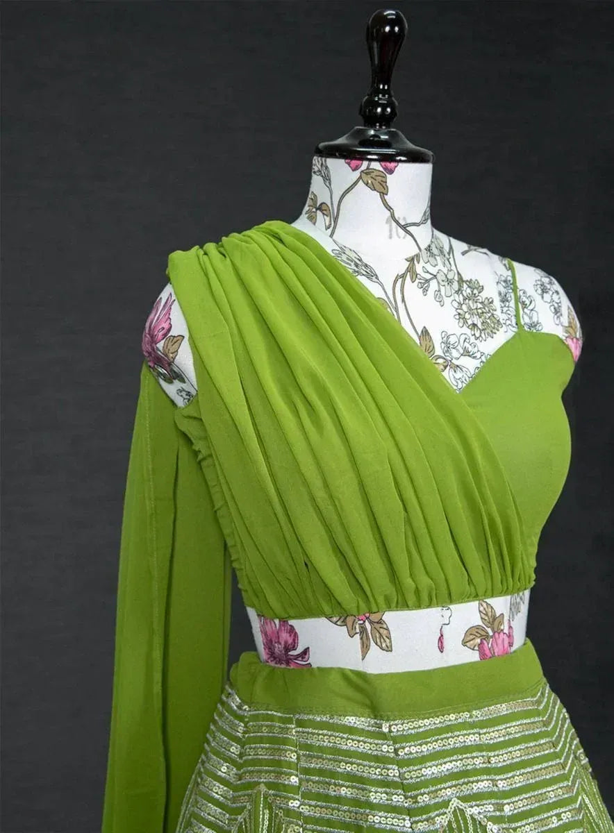 Vibrant green pleated lehenga choli with sequin skirt, floral mannequin display