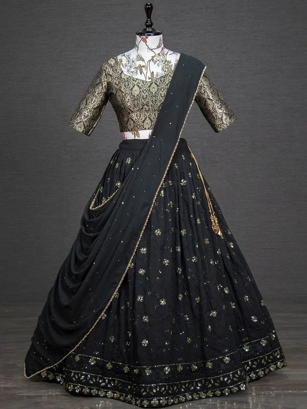 Black and gold embroidered lehenga choli with floral motifs and sequin detailing, perfect for Indian ethnic wear.