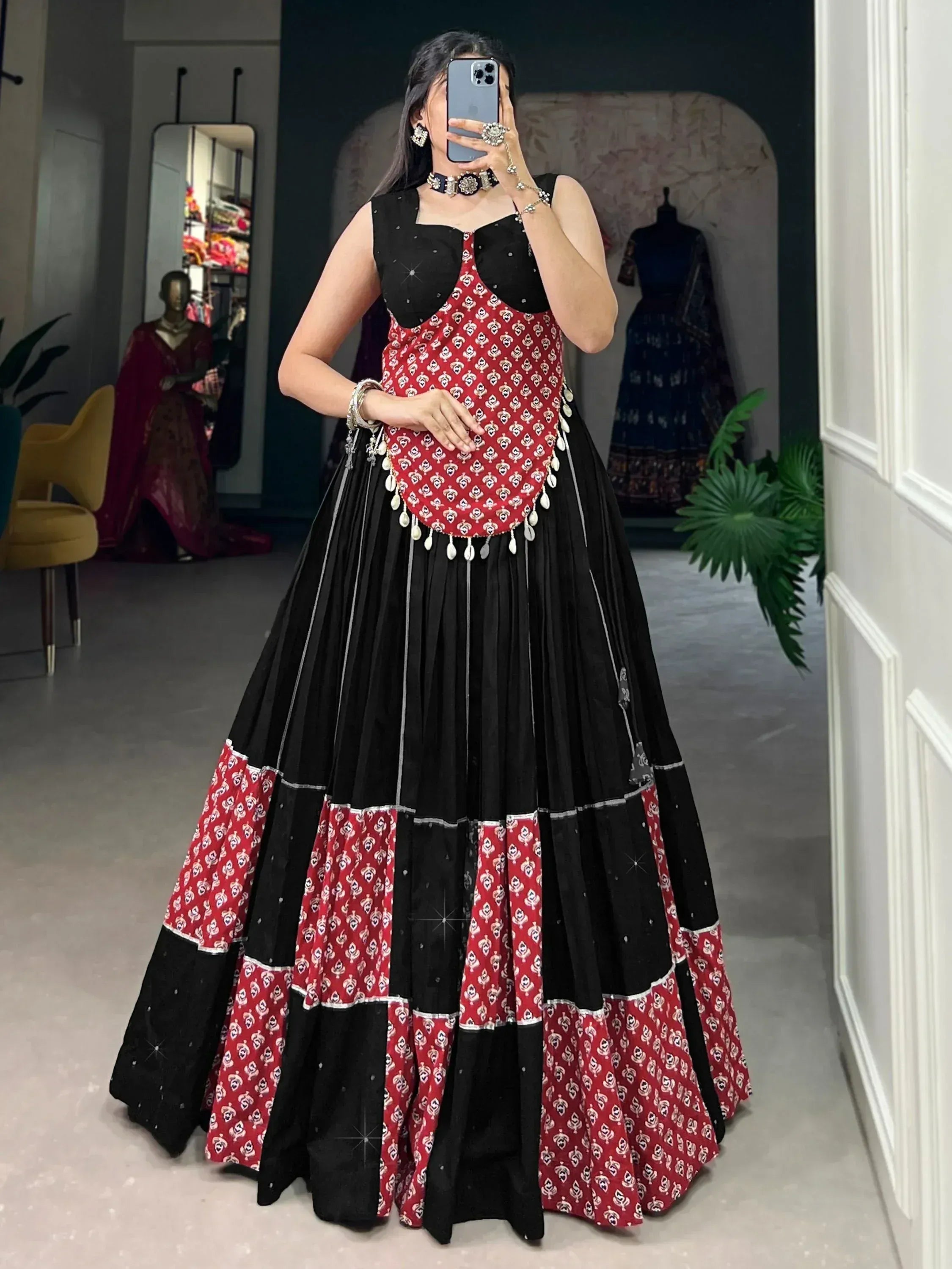 Black and red printed ethnic gown with layered skirt and mirror work, perfect for festive occasions