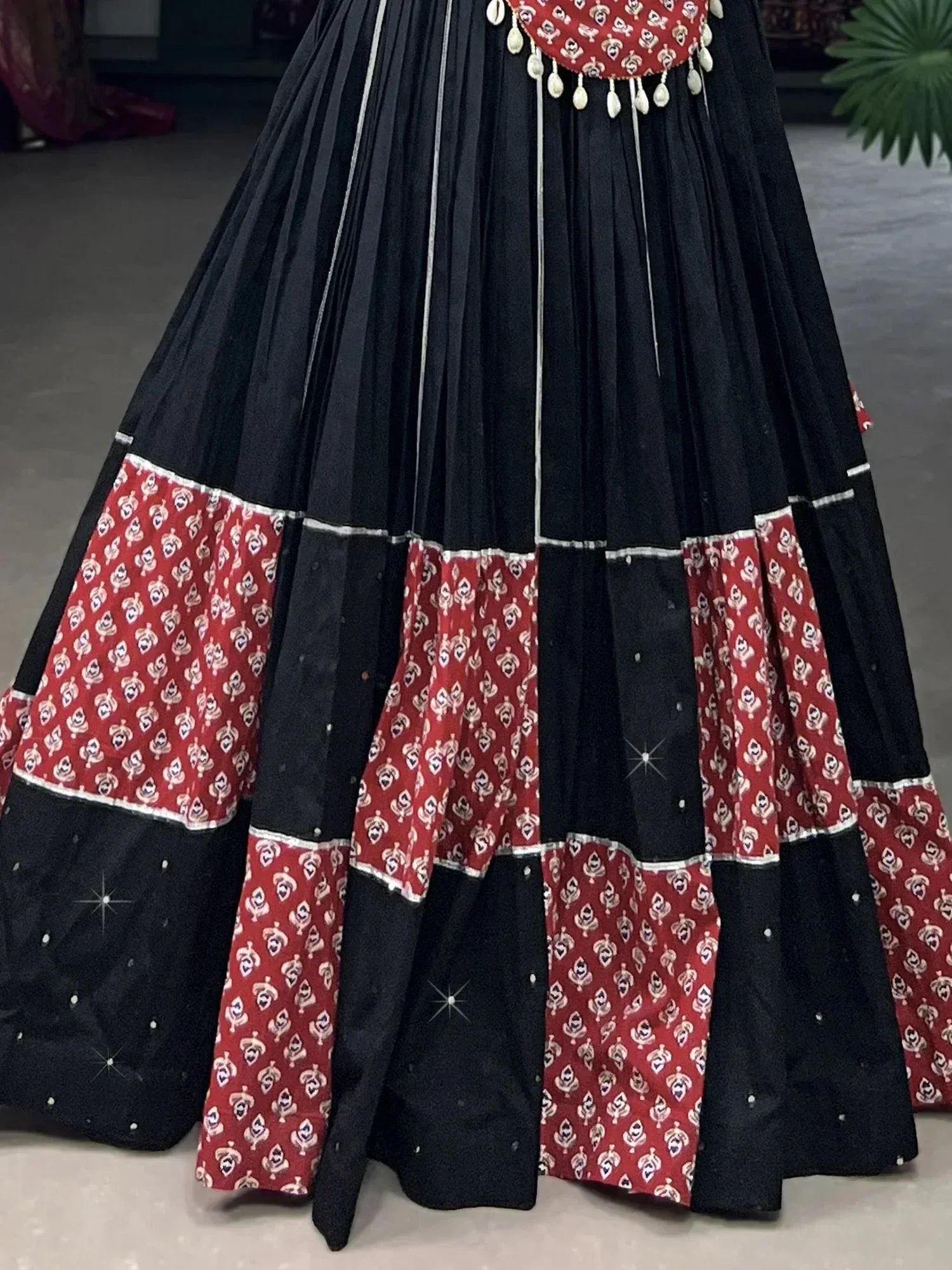 Black and red printed ethnic lehenga skirt with pleats and mirror work, perfect for festive occasions.