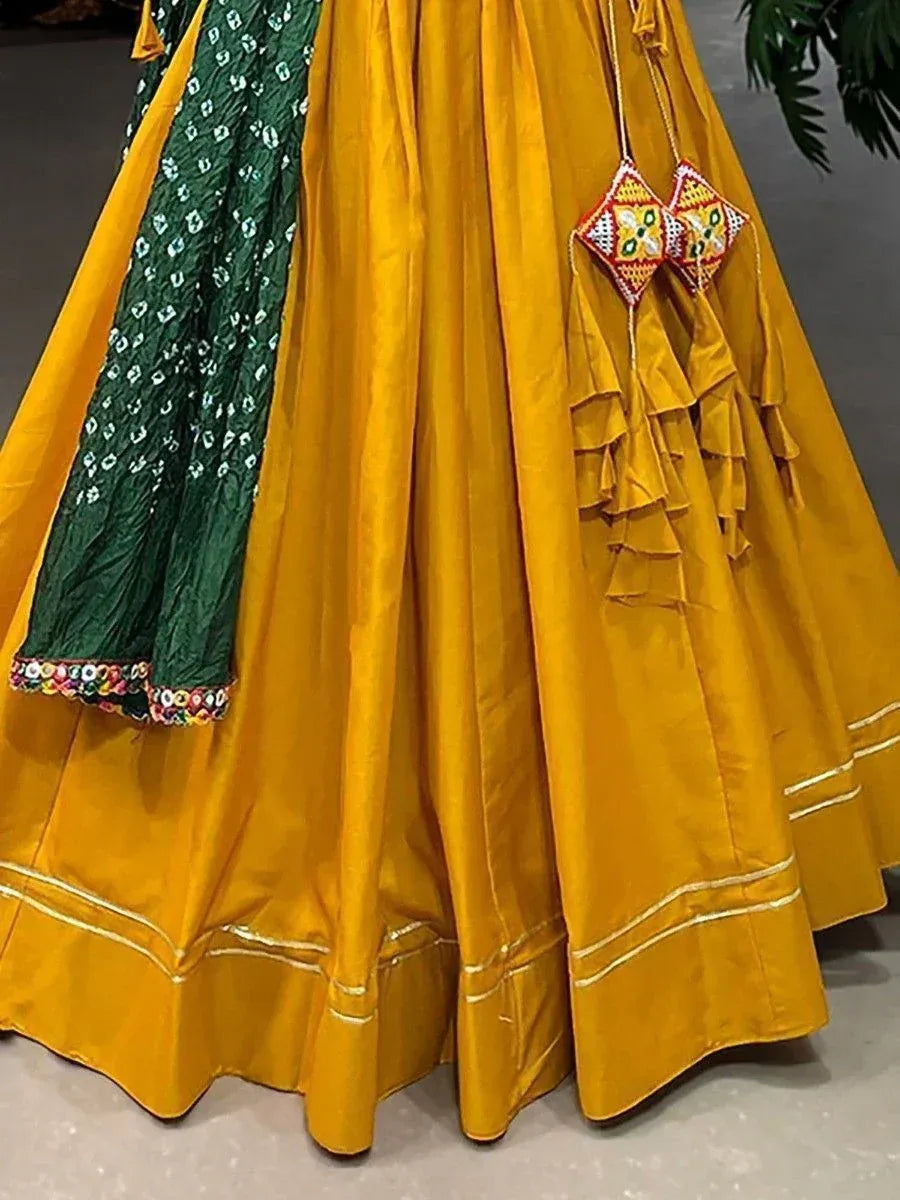 Yellow lehenga with green dupatta, ruffles, and embroidered tassels for ethnic wear