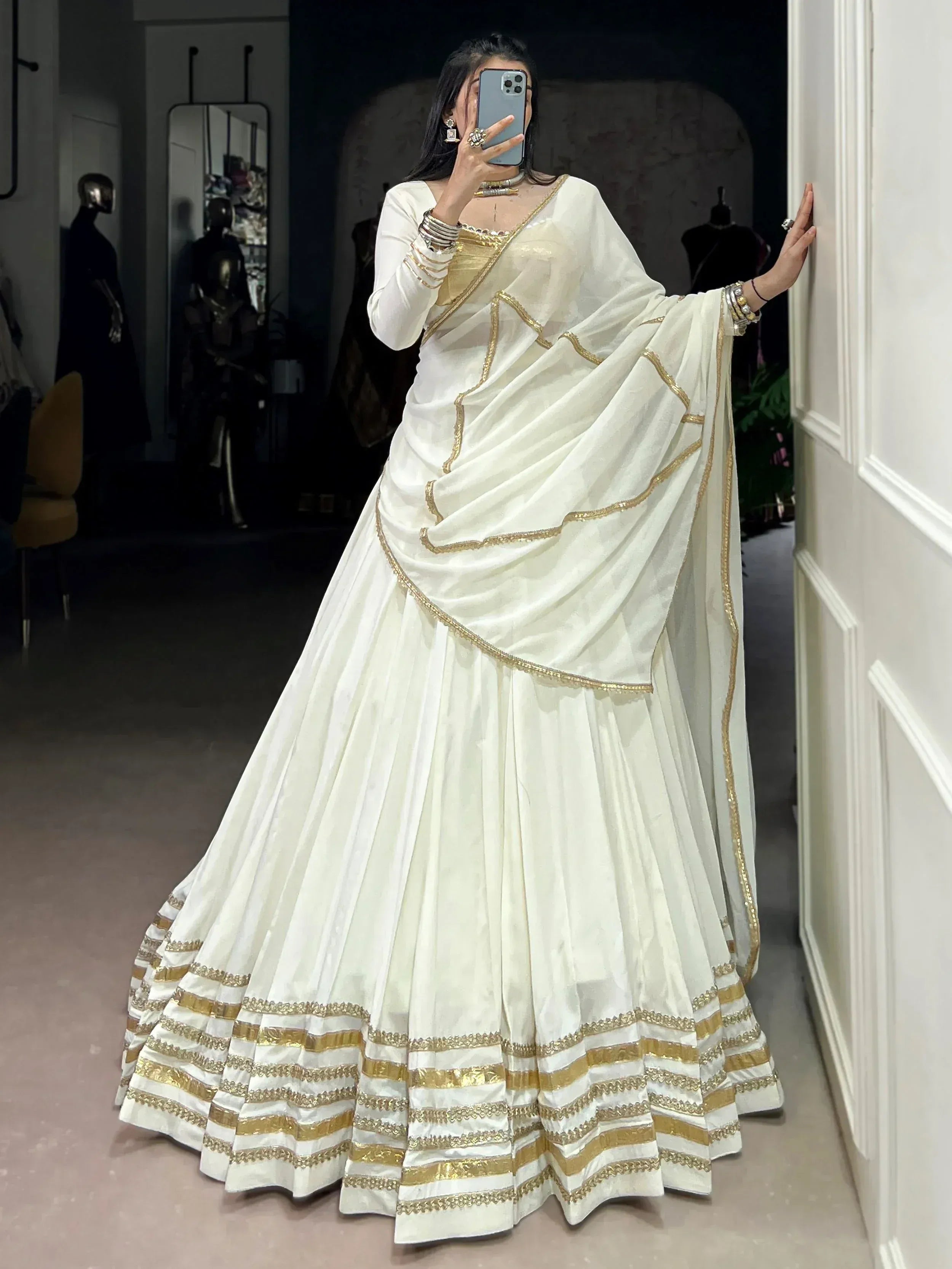 White and gold designer lehenga choli with embroidered borders, perfect for Indian ethnic wear occasions.