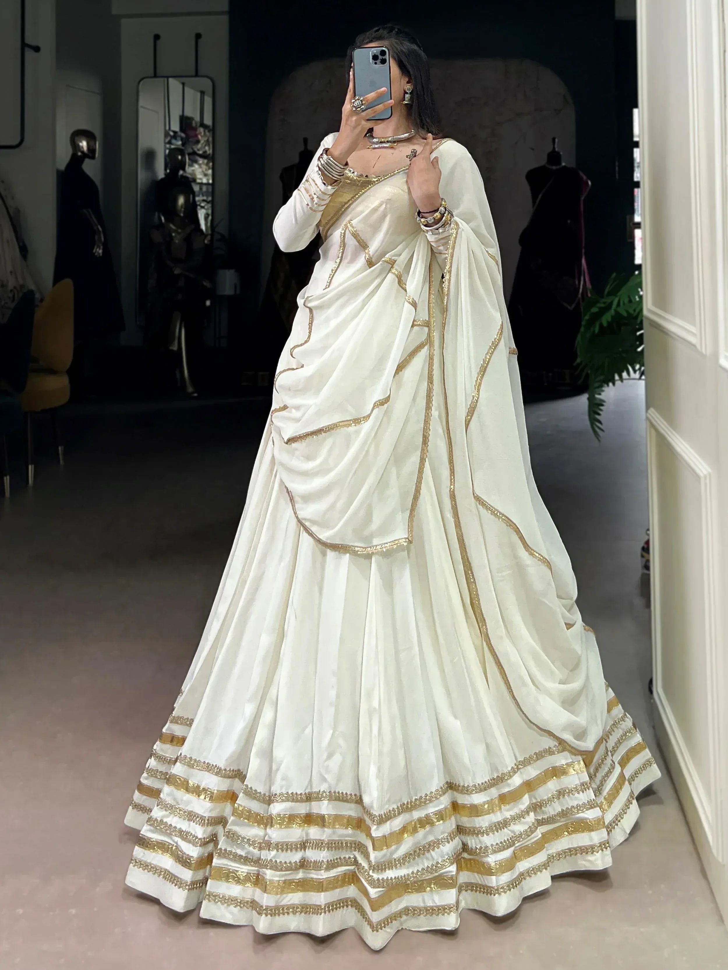 White and gold designer lehenga choli with intricate embroidery, perfect for Indian ethnic wear occasions.