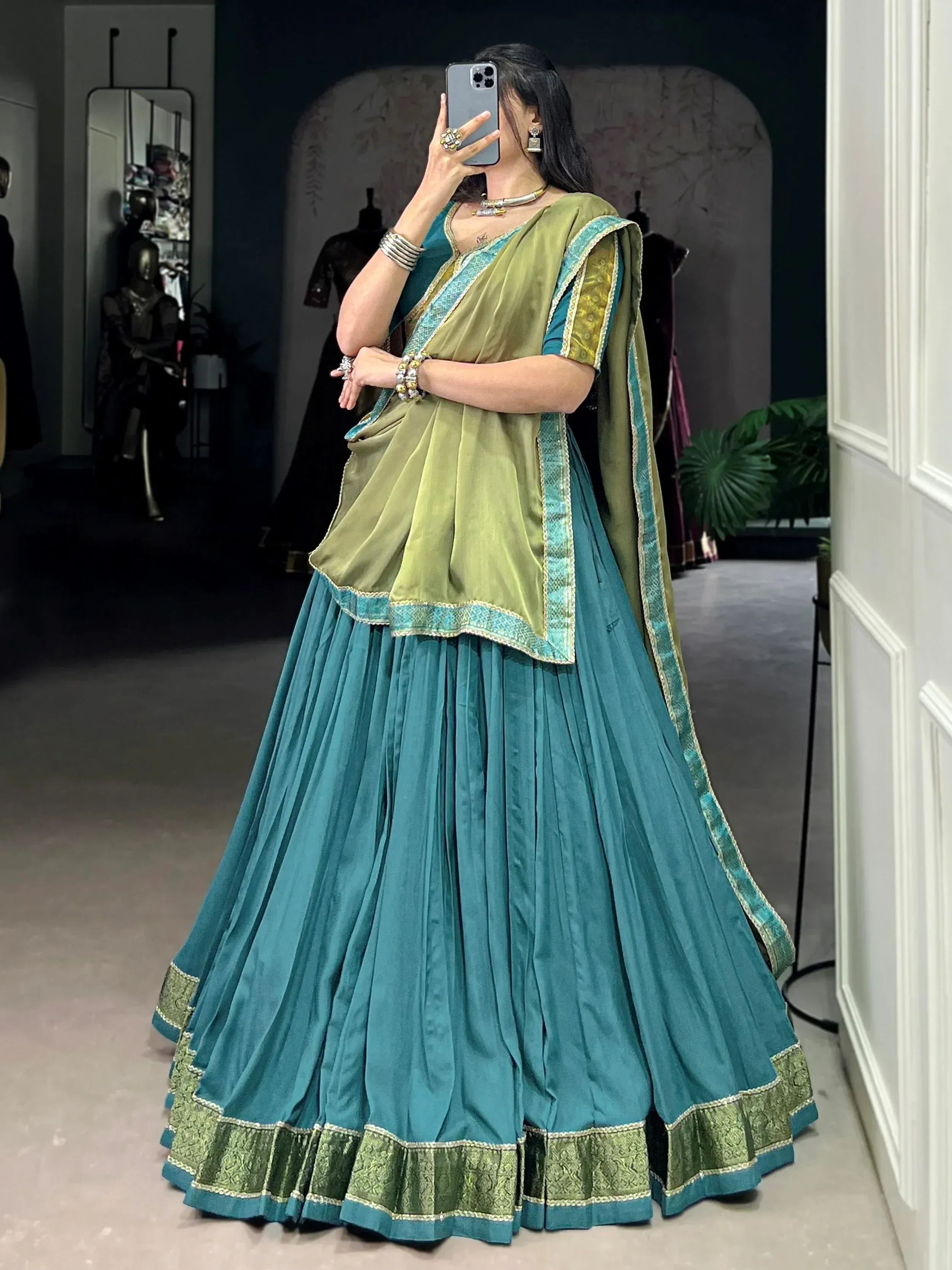 Teal and olive green designer lehenga choli with embroidered borders, perfect for Indian ethnic wear occasions.