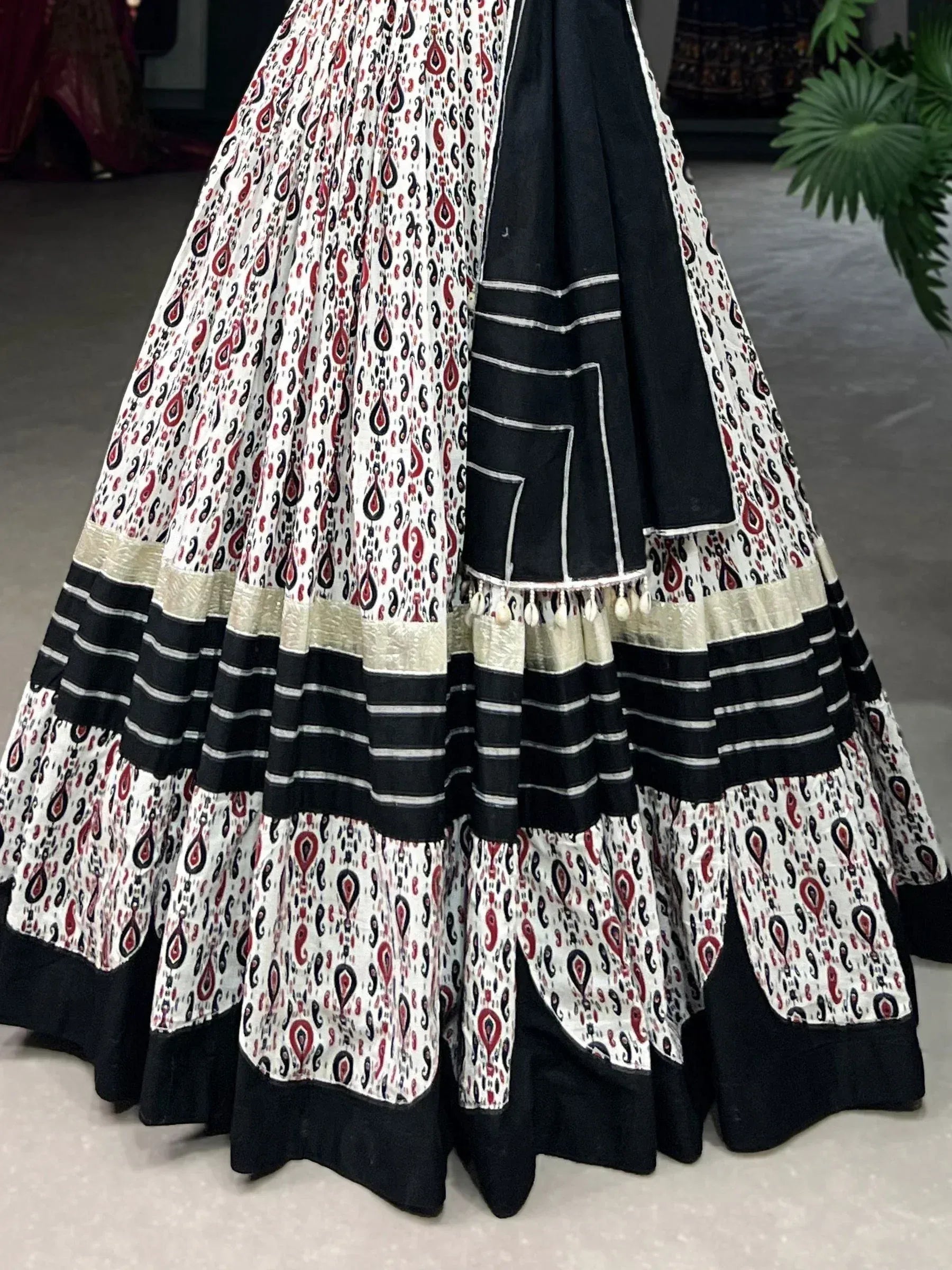 Black and white printed lehenga with red paisley patterns and striped border, ethnic Indian wear