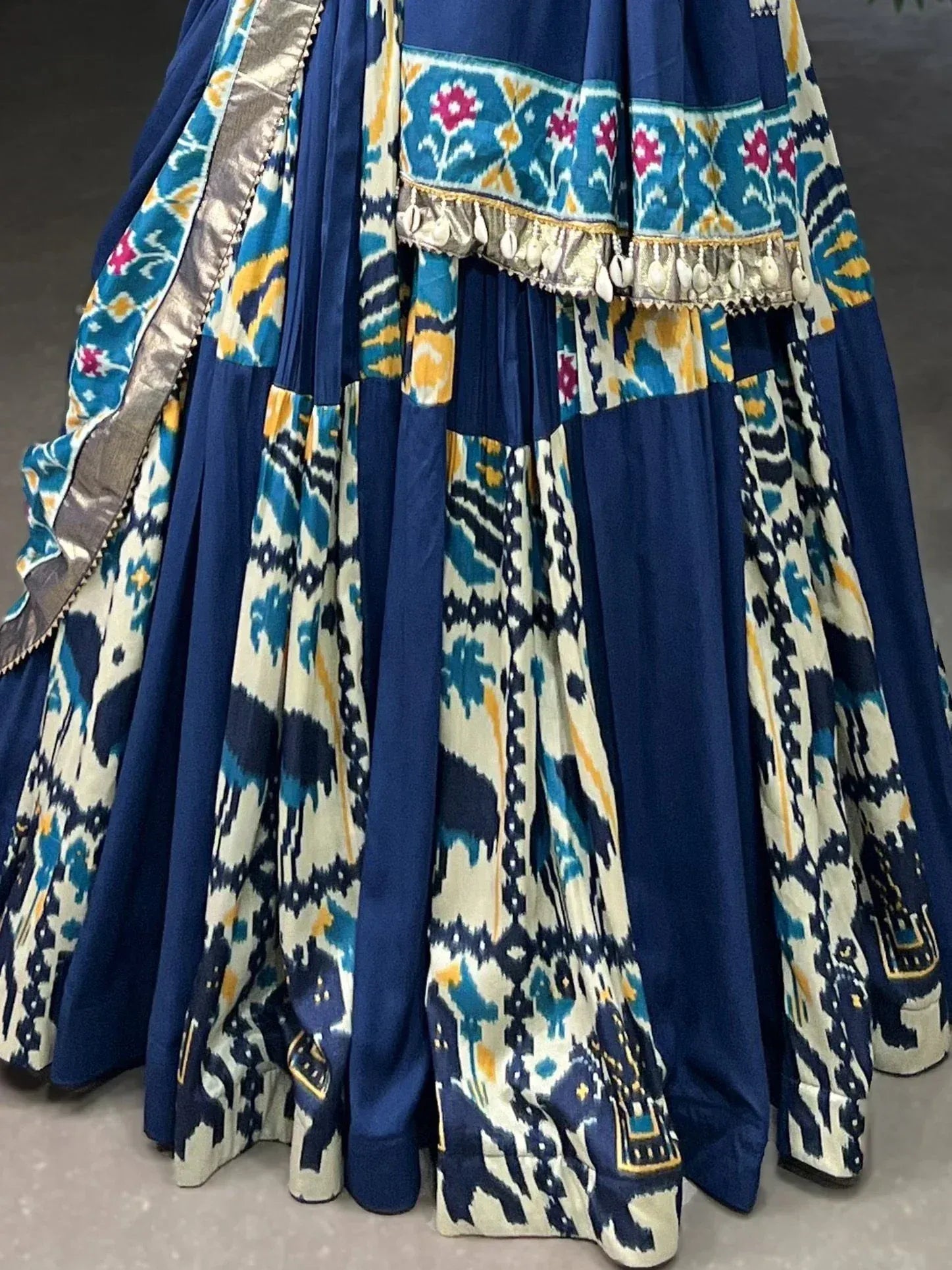 Blue and cream ikat print lehenga with floral border and tassels