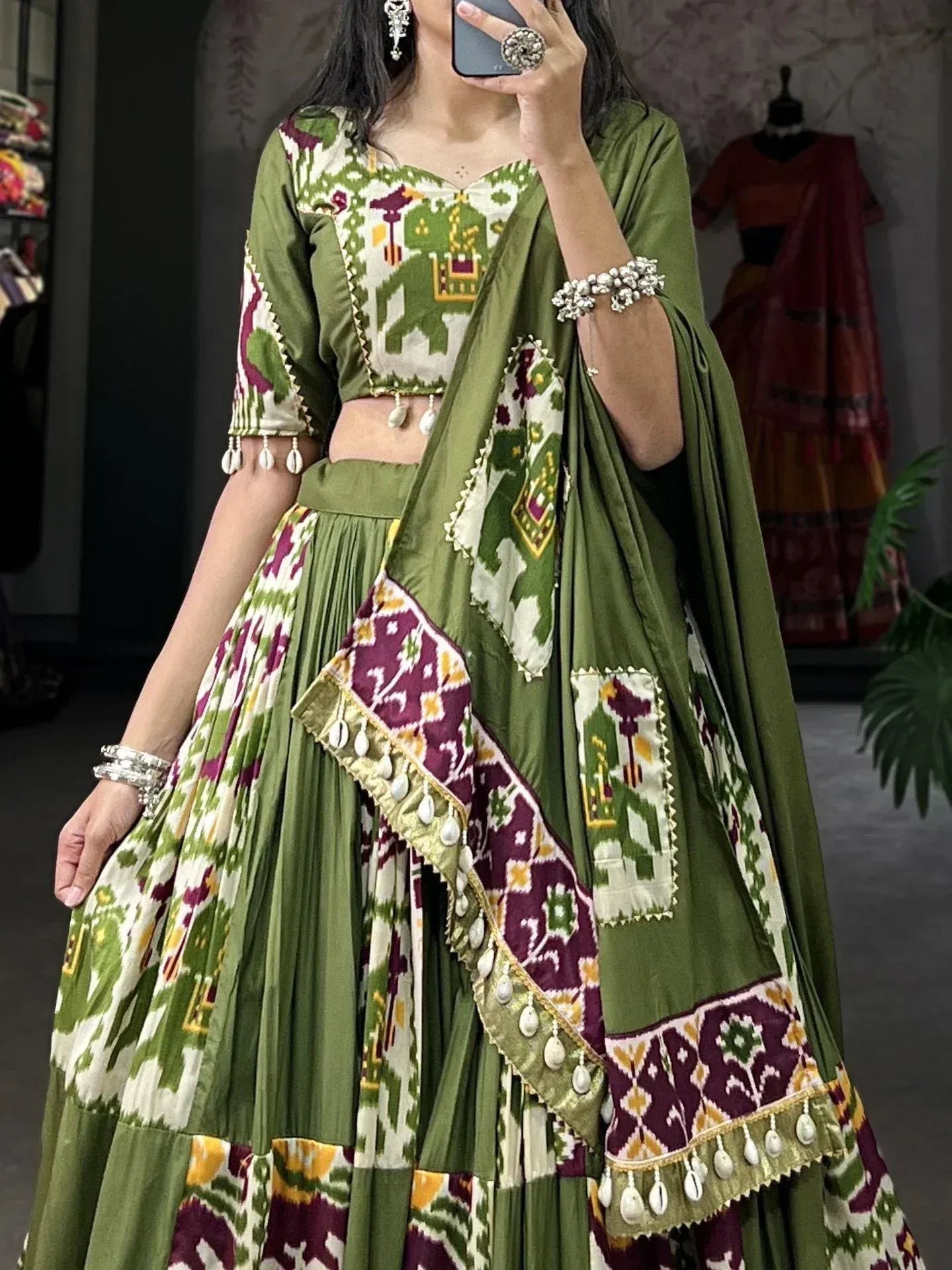 Green and purple ikat print lehenga choli with elephant motifs and shell tassels, ethnic Indian wear