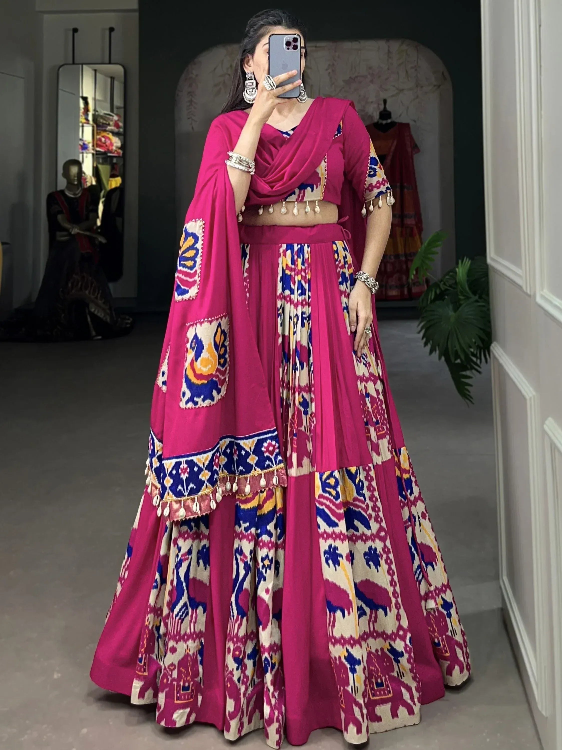 Vibrant pink lehenga choli with colorful ikat print and tassel details, perfect for Indian ethnic occasions.