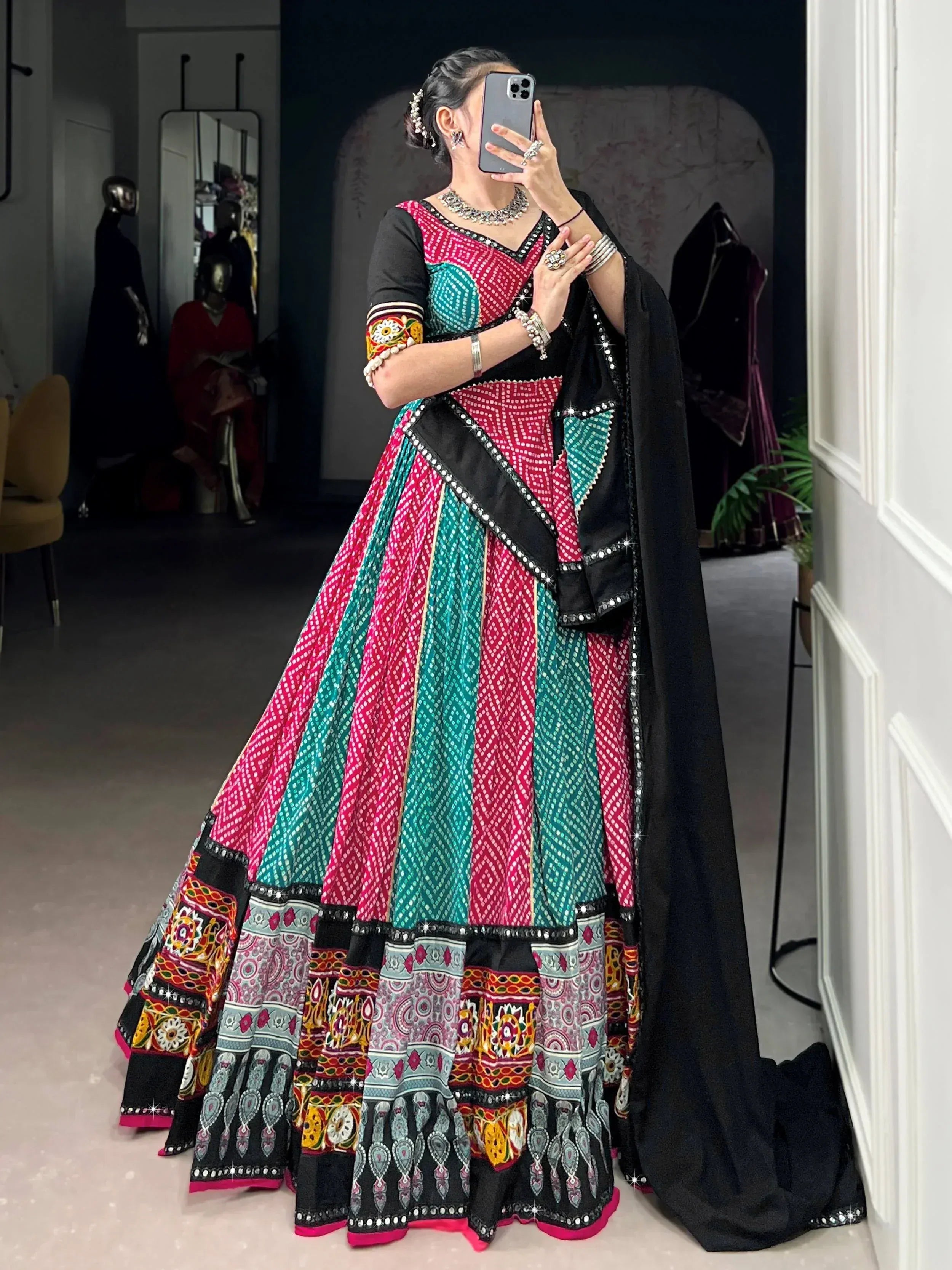 Woman in vibrant pink and teal embroidered lehenga choli with black dupatta, traditional Indian ethnic wear